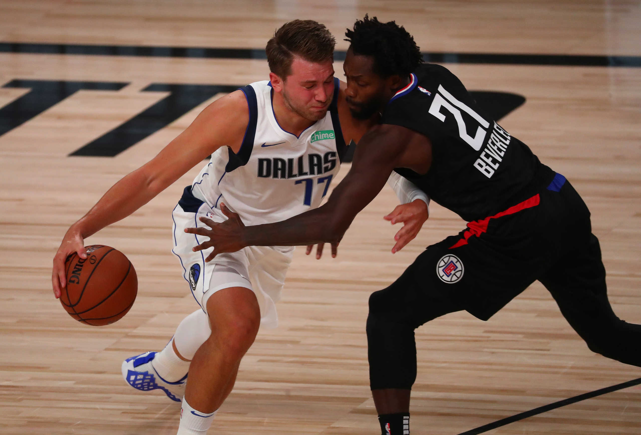 Aug 17, 2020; Lake Buena Vista, Florida, USA; Dallas Mavericks guard Luka Doncic (77) drives against LA Clippers guard Patrick Beverley (21) in the first half in game one of the first round of the 2020 NBA Playoffs at AdventHealth Arena. Mandatory Credit: Kim Klement-USA TODAY Sports