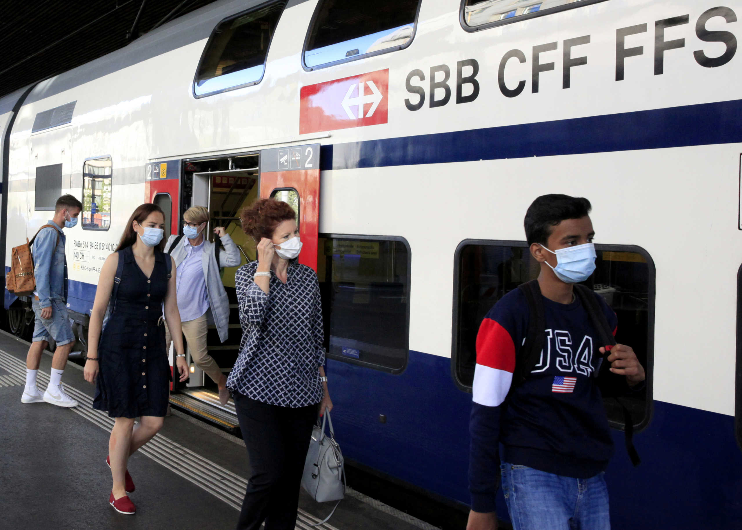 FILE PHOTO: Passengers wear protective masks as they leave a train of Swiss railway operator SBB, at the Hauptbahnhof central station in Zurich, Switzerland July 6, 2020.   REUTERS