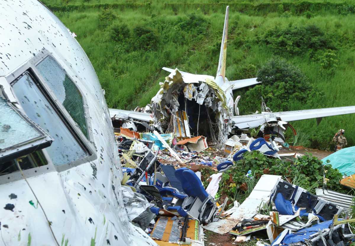 A security official inspects the site where a passenger plane crashed when it overshot the runway at the Calicut International Airport in Karipur, in the southern state of Kerala, India, August 8, 2020. REUTERS