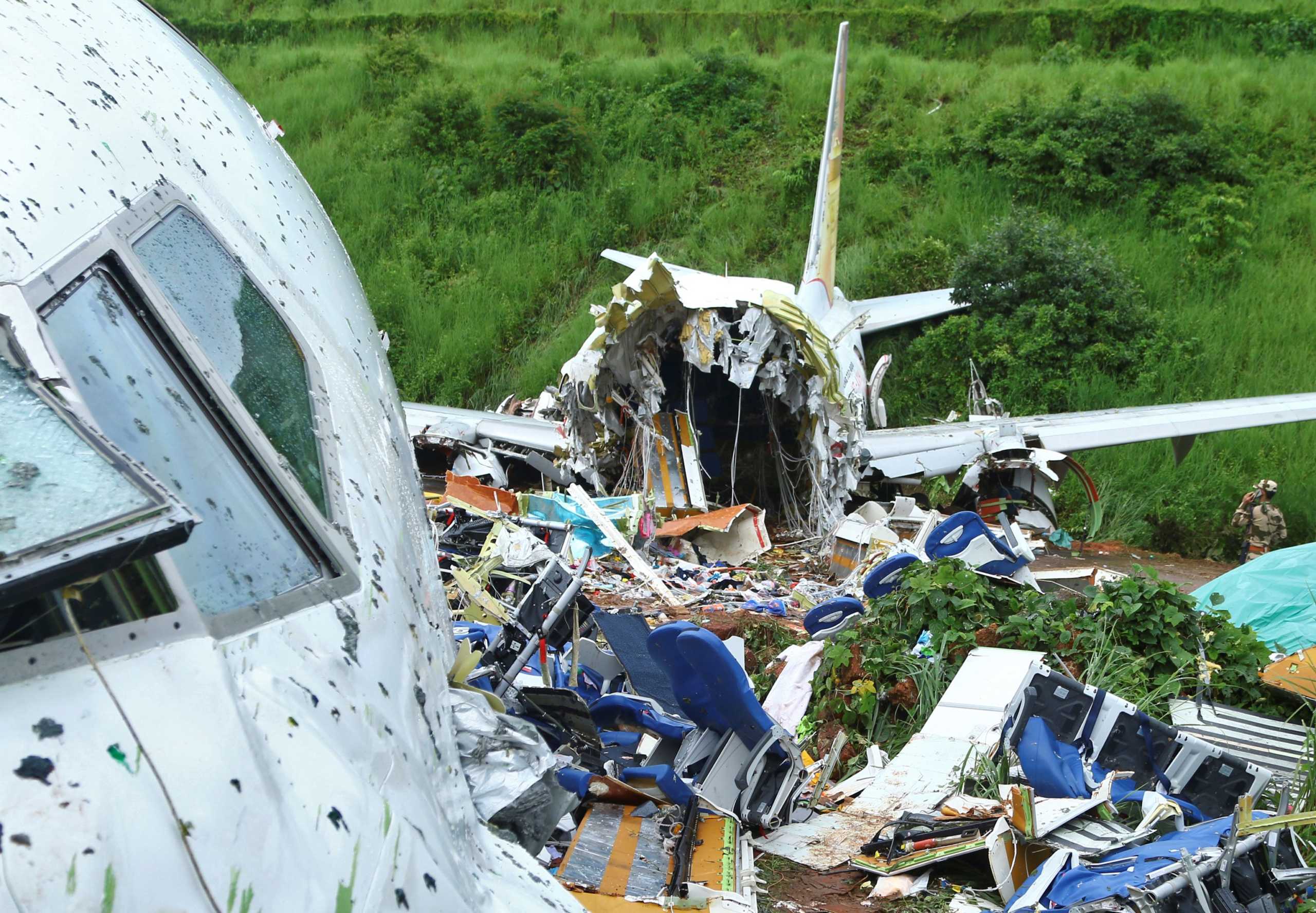 A security official inspects the site where a passenger plane crashed when it overshot the runway at the Calicut International Airport in Karipur, in the southern state of Kerala, India, August 8, 2020. REUTERS