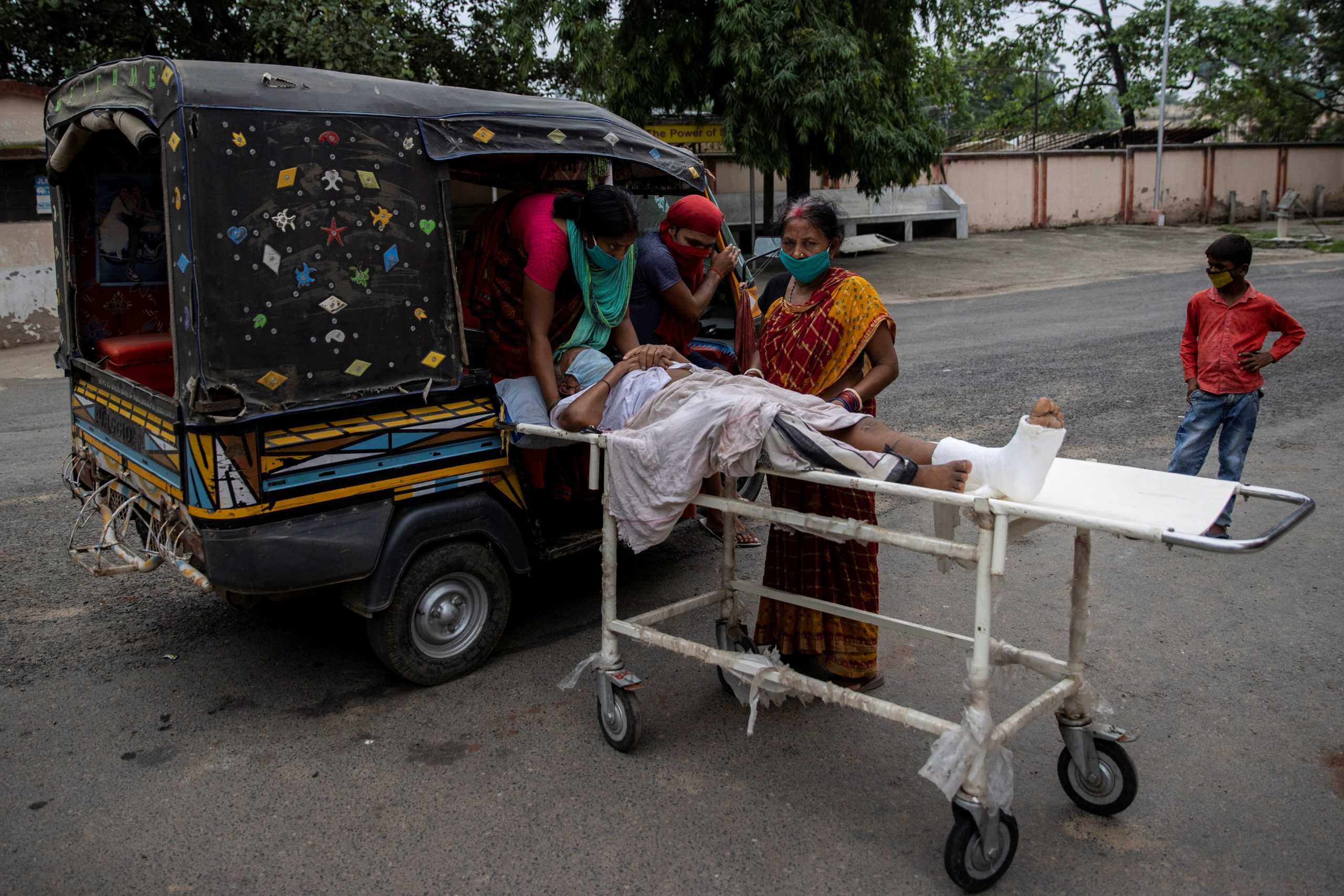 A patient is moved by relatives onto an auto-rickshaw as they take him home after he received treatment at Jawahar Lal Nehru Medical College and Hospital, during the coronavirus disease (COVID-19) outbreak, in Bhagalpur, in Bihar, India, July 27, 2020. REUTERS