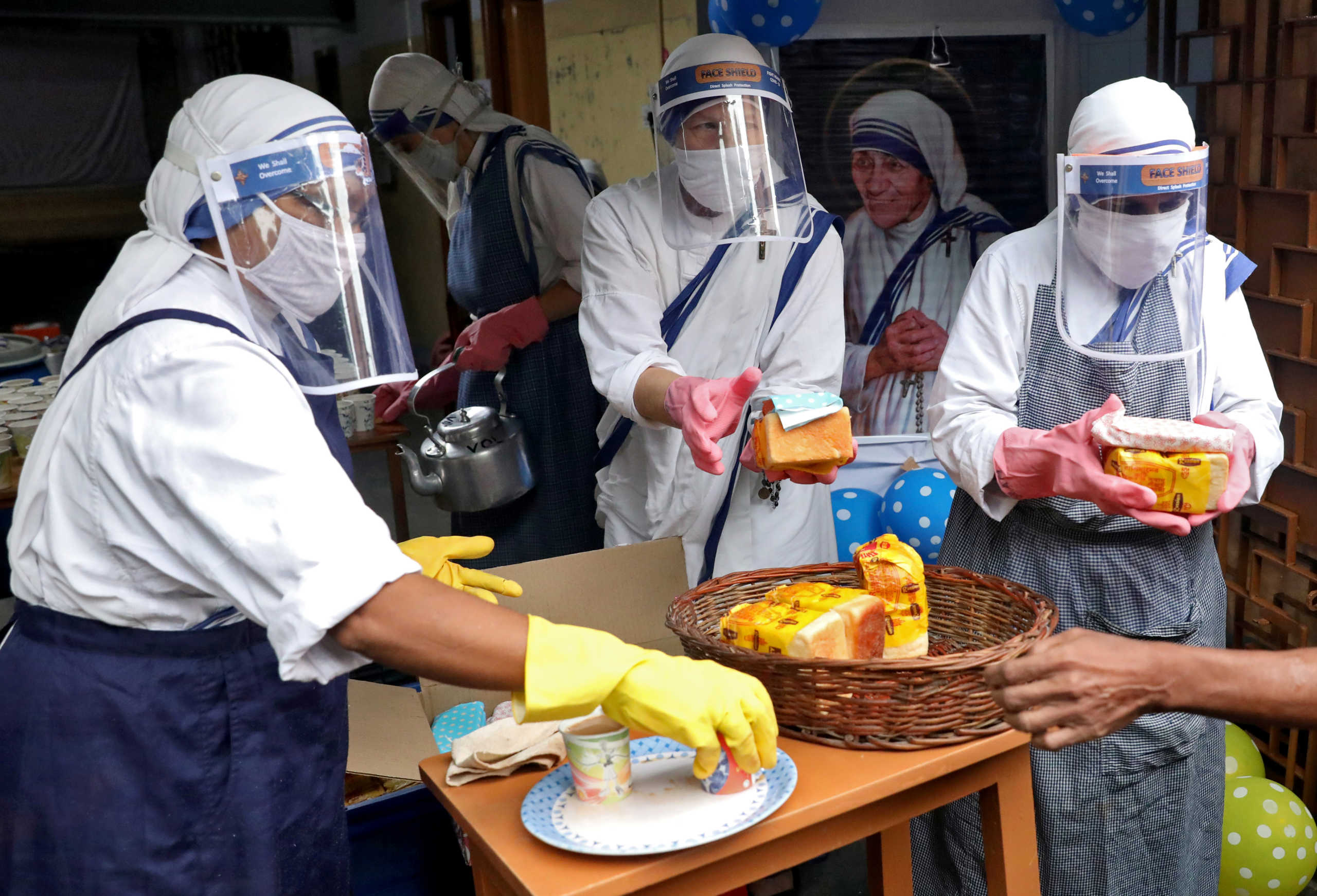 Catholic nuns from the Missionaries of Charity, the global order of nuns founded by Saint Mother Teresa, wear protective face shields as they prepare to distribute free snacks and tea among the poor after offering prayers to mark her 110th birth anniversary, amid the coronavirus disease (COVID-19) outbreak, in Kolkata, India, August 26, 2020. REUTERS