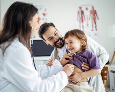 Paediatrician Examining Child with Stethoscope While Father Watches