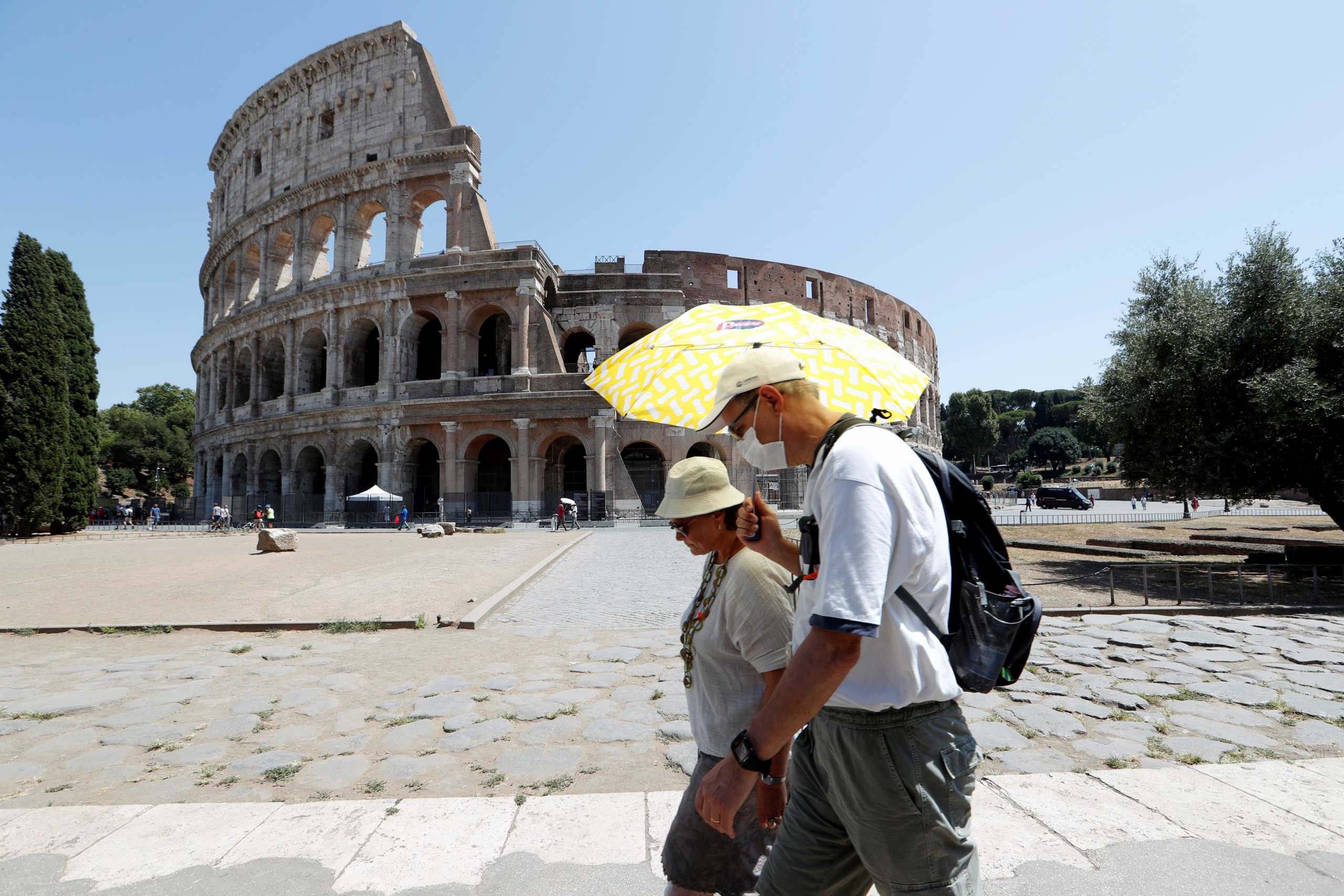 People walk past the Colosseum, amid the outbreak of the coronavirus disease (COVID-19), in Rome, Italy, July 31, 2020. REUTERS