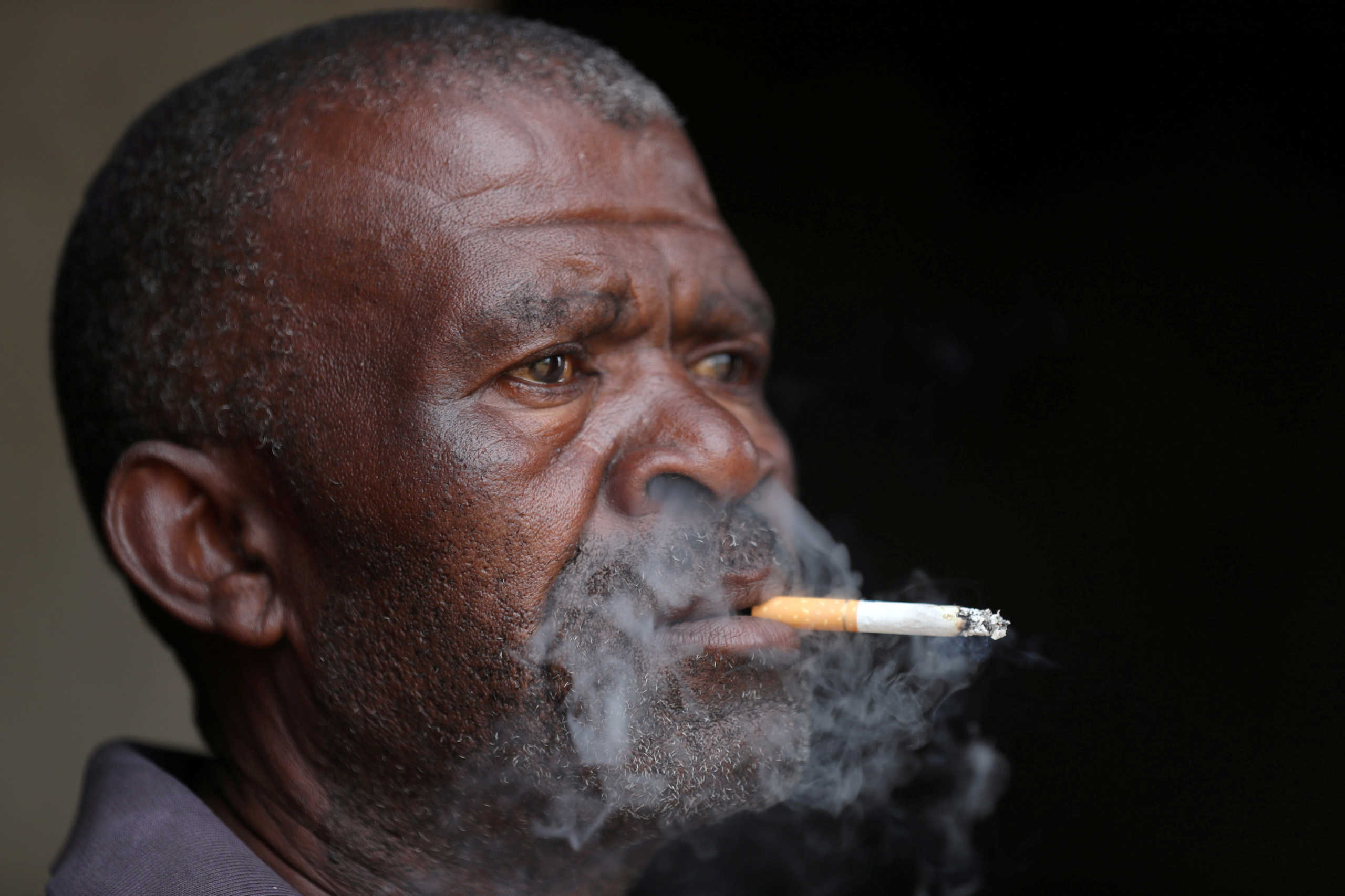 A man smokes a cigarette as South Africa loosens a nationwide lockdown aimed at limiting the spread of the coronavirus disease (COVID-19) in Johannesburg, South Africa August 18, 2020. REUTERS