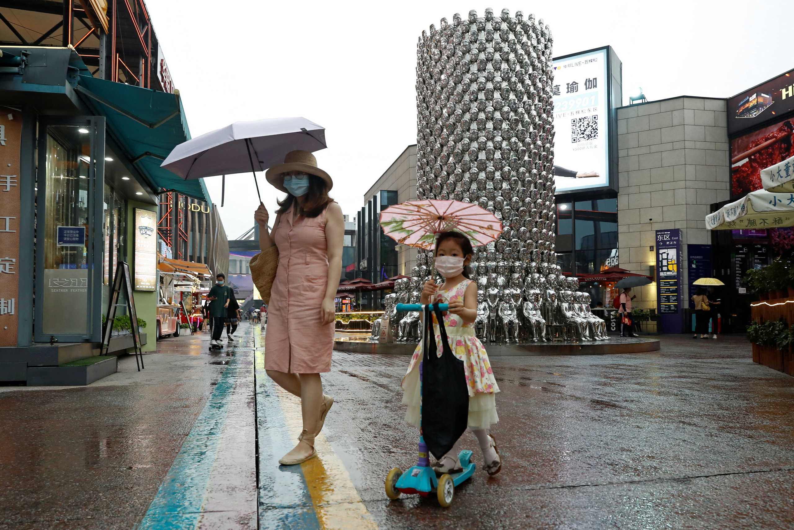 FILE PHOTO: People wear protective face masks as they are seen in a shopping complex after an outbreak of the coronavirus disease (COVID-19) in Beijing, China July 17, 2020. REUTERS