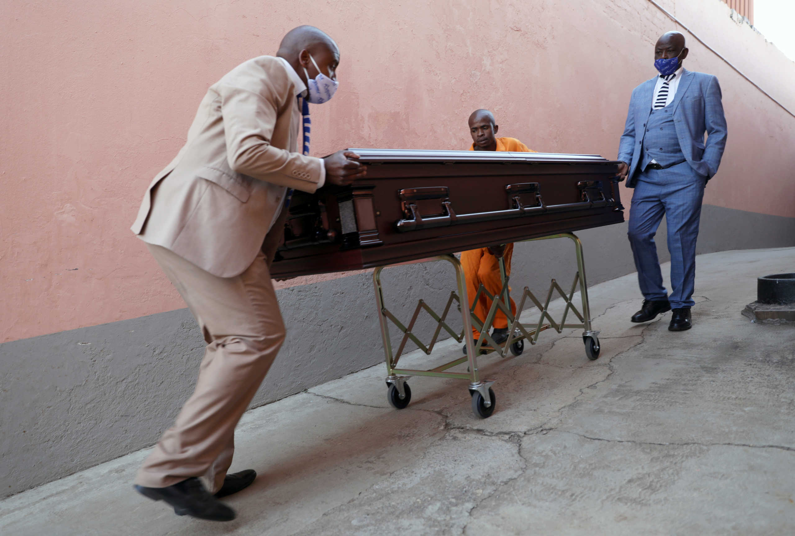 Undertakers of Sopema Funerals prepare to transport the body of a deceased person ahead of the funeral service, amid a nationwide coronavirus disease (COVID-19) lockdown, in Soweto, south-west of Johannesburg, South Africa August 4, 2020. REUTERS