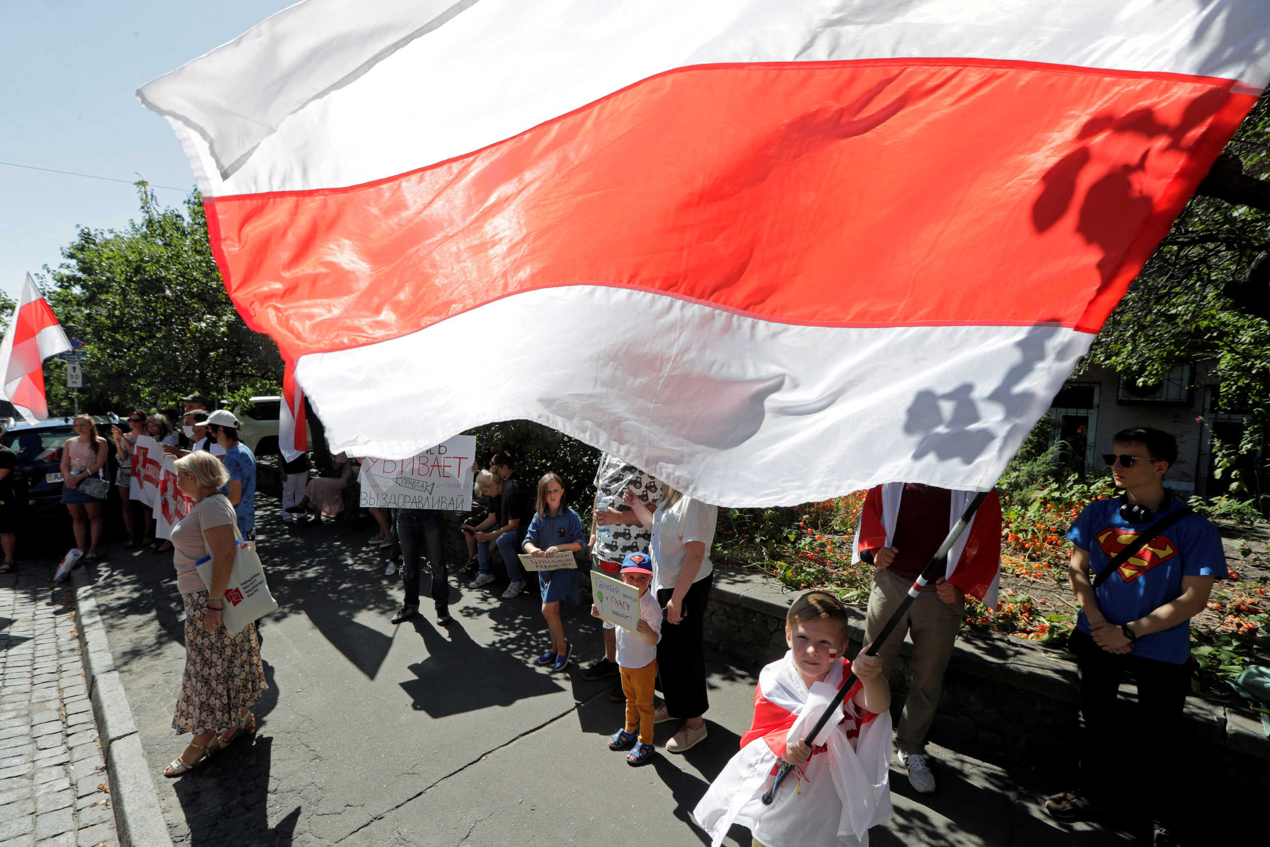 A boy waves a Belarusian historical white-red-white flag during a rally in support of anti-government protests in Belarus against presidential election results, in front of the Belarusian embassy in Kyiv, Ukraine August 30, 2020. REUTERS