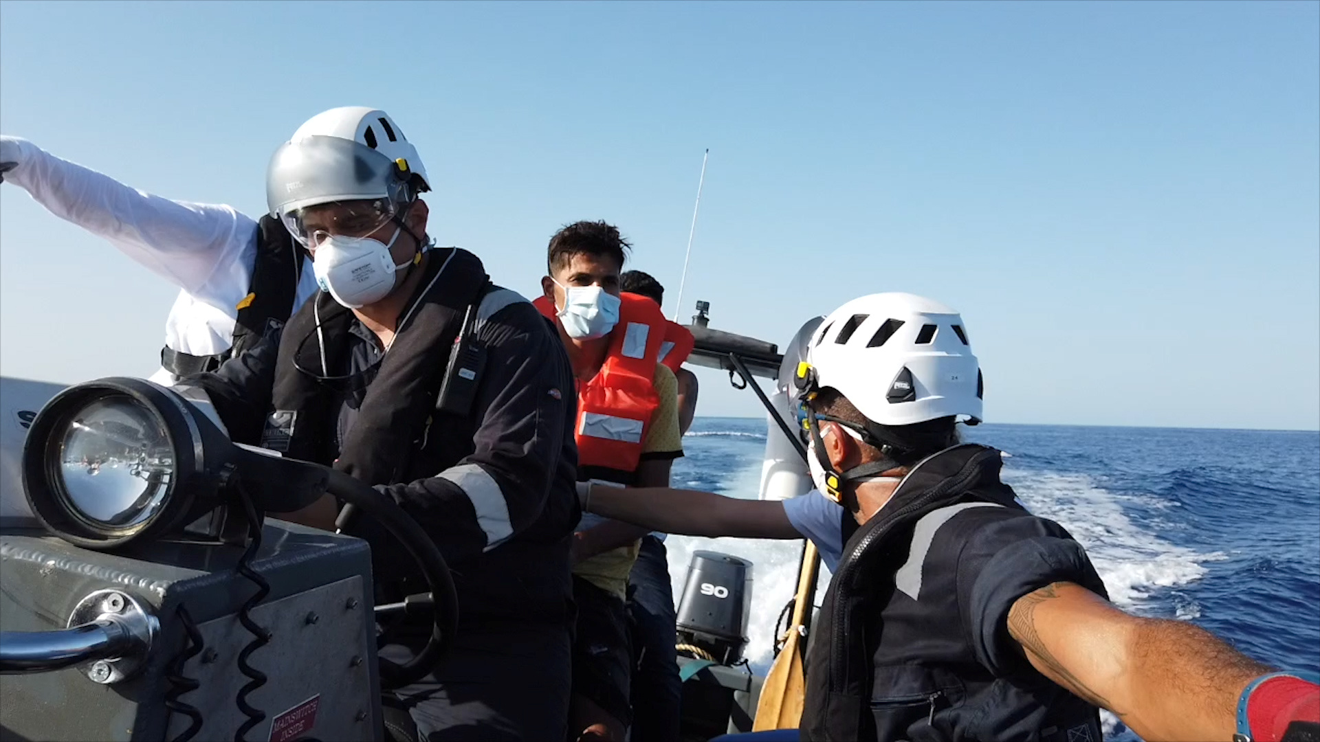 A member of the rescue team speaks with a migrant on a rubber dinghy, at sea off the coast of Libya, August 22, 2020, in this still image taken from the video. Sea-Watch