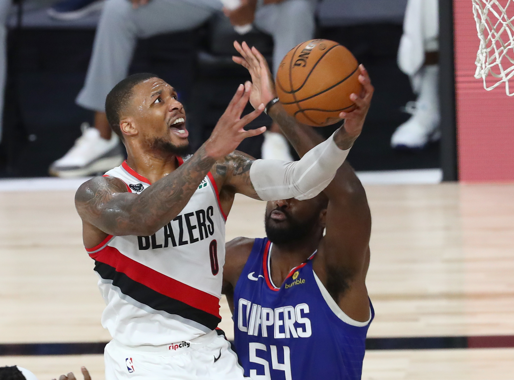 Aug 8, 2020; Lake Buena Vista, Florida, USA;  Portland Trail Blazers guard Damian Lillard (0) shoots past LA Clippers forward Patrick Patterson (54) during the second half in an NBA basketball game at The Field House. Mandatory Credit: Kim Klement-USA TODAY Sports