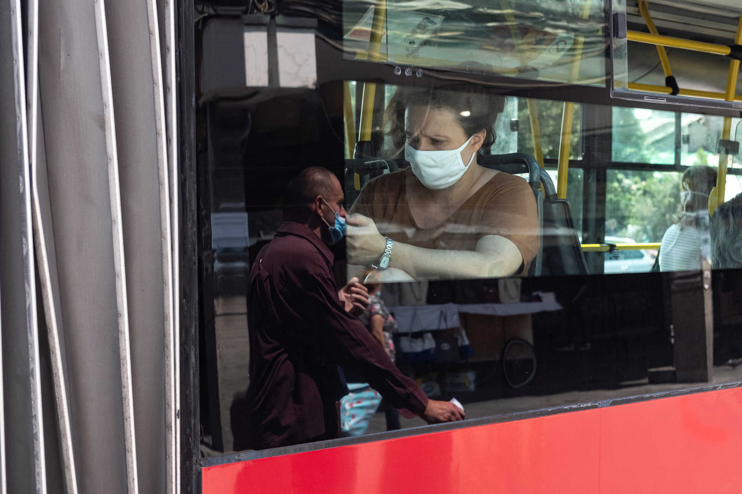 A woman wearing a protective mask sits in a bus, as the spread of the coronavirus disease (COVID-19) continues in Belgrade, Serbia, July 21, 2020. REUTERS