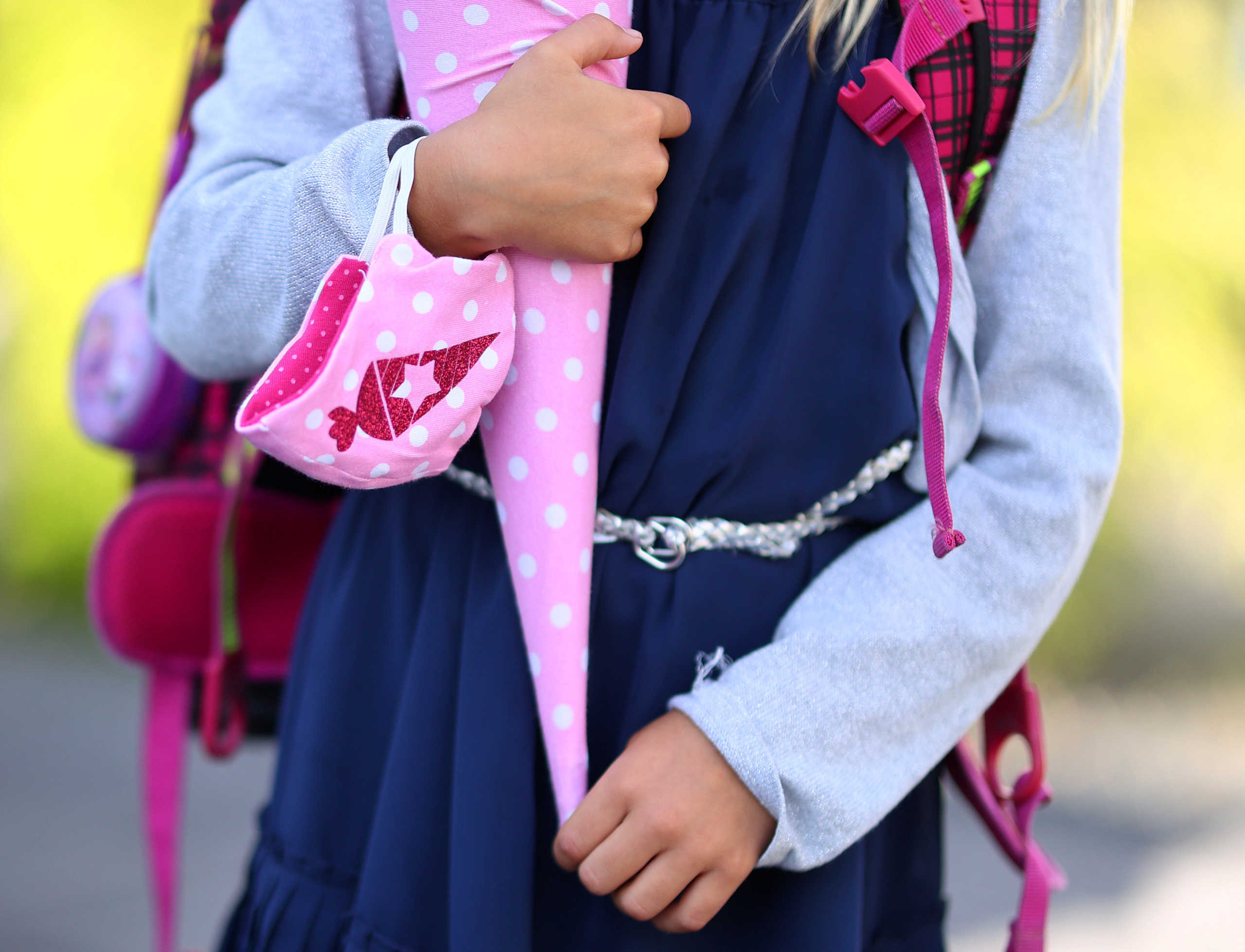 Six-year-old Tilda holds her customised face mask and school cone before walking to primary school for the first time after the lockdown due the outbreak of the coronavirus disease (COVID-19) in Rodenbach, Germany, August 18, 2020. REUTERS