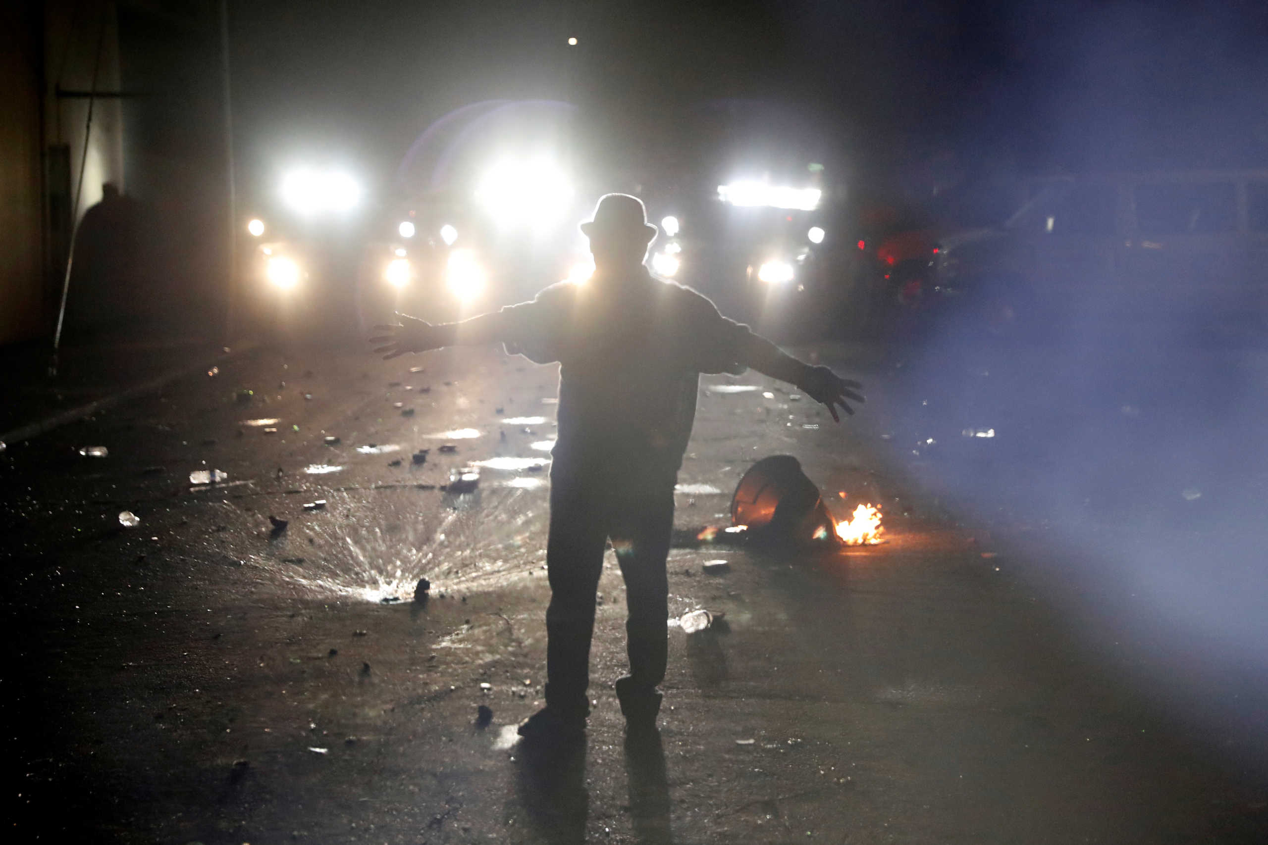 A man raises his hands in front of police during a protest against police violence and racial injustice in Portland, Oregon, U.S., August 23, 2020. Picture taken August 23, 2020. REUTERS