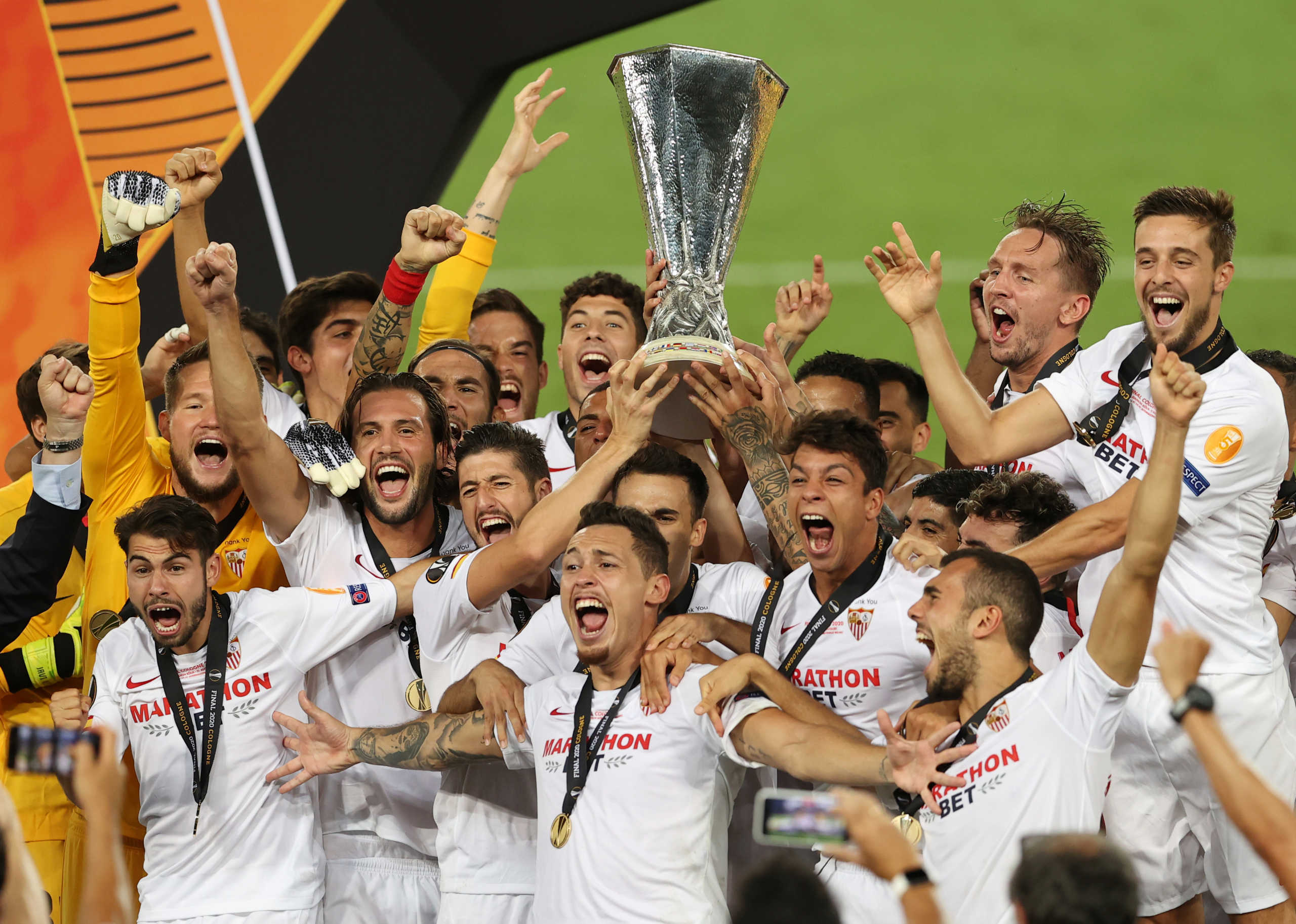 Soccer Football - Europa League - Final - Sevilla v Inter Milan - RheinEnergieStadion, Cologne, Germany - August 21, 2020  Sevilla's Lucas Ocampos with teammates celebrate with the trophy after winning the UEFA Europa League, as play resumes behind closed doors following the outbreak of the coronavirus disease (COVID-19)   Lars Baron