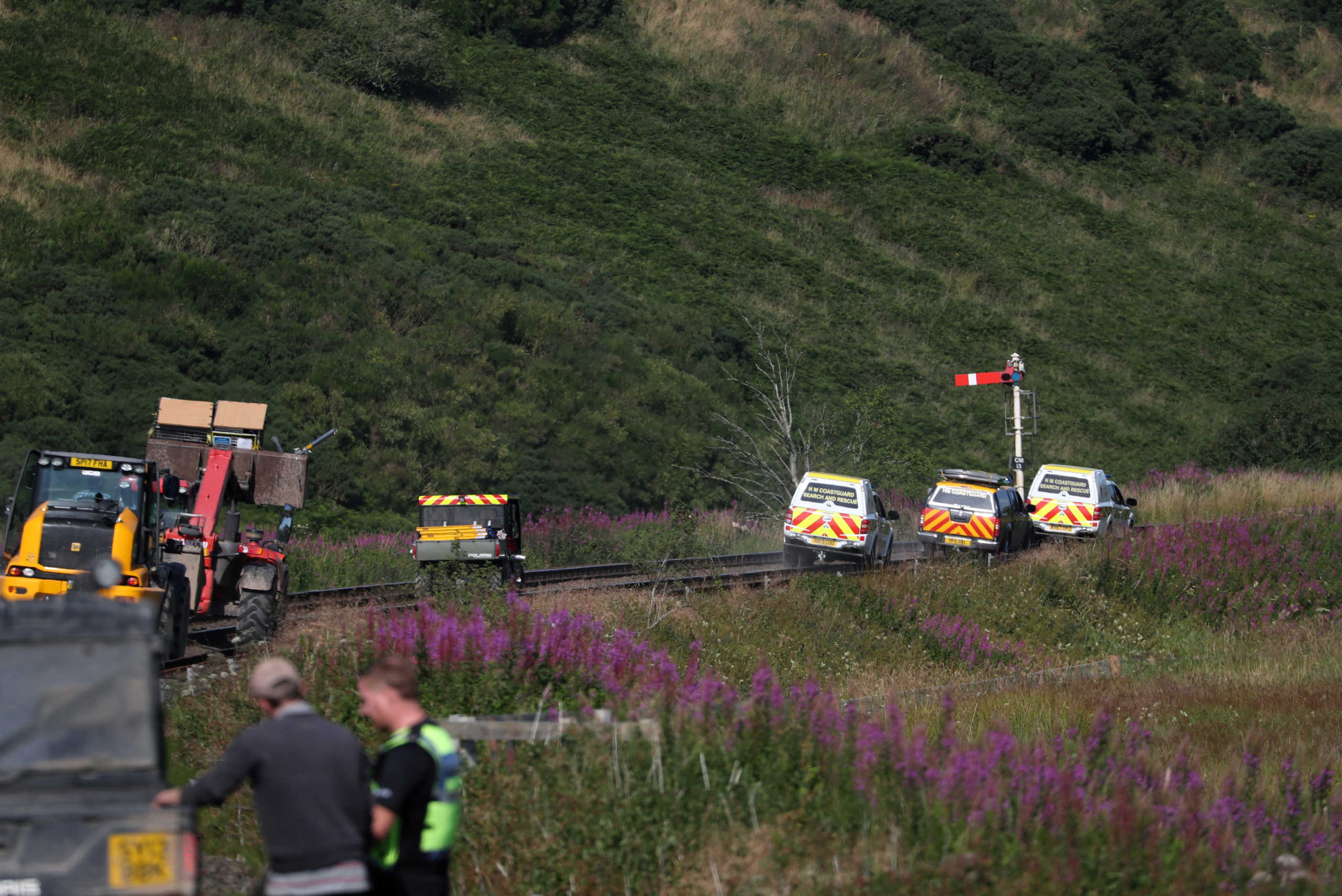 Emergency service vehicles ride along the tracks near the scene of a derailed passenger train, near Carmont, Stonehaven, Scotland, Britain, August 12, 2020. REUTERS