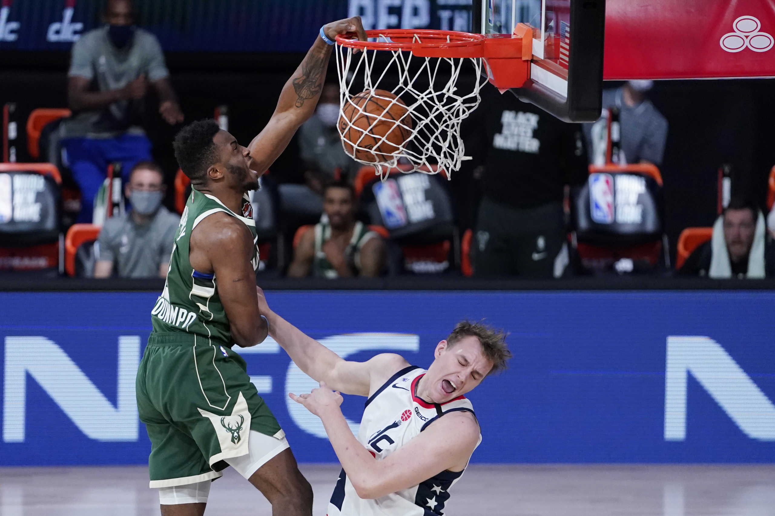 Aug 11, 2020; Lake Buena Vista, Florida, USA; Milwaukee Bucks' Thanasis Antetokounmpo, left, slams a dunk over Washington Wizards' Anzejs Pasecniks (18) during the second half of an NBA basketball game, Tuesday, Aug. 11, 2020, in Lake Buena Vista, Fla. at Visa Athletic Center. Mandatory Credit: Ashley Landis