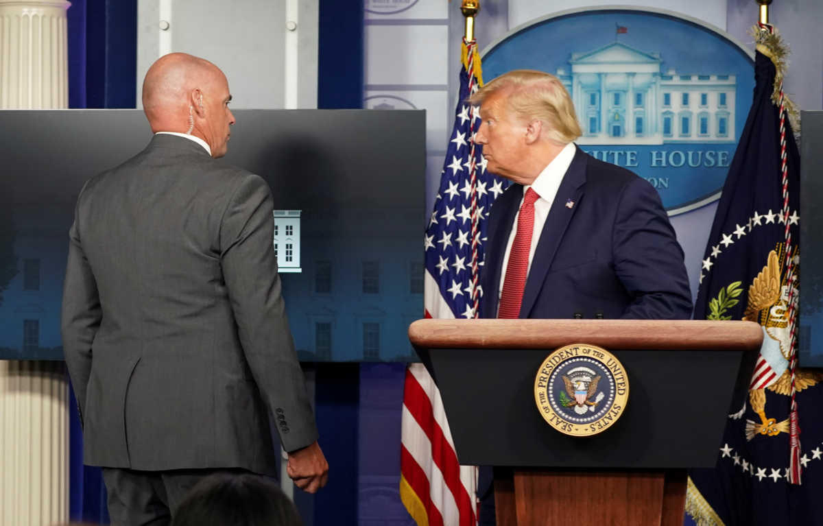 A Secret Service agent escorts U.S. President Donald Trump from a coronavirus disease (COVID-19) pandemic briefing after a shooting outside the White House in Washington, U.S., August 10, 2020.  REUTERS