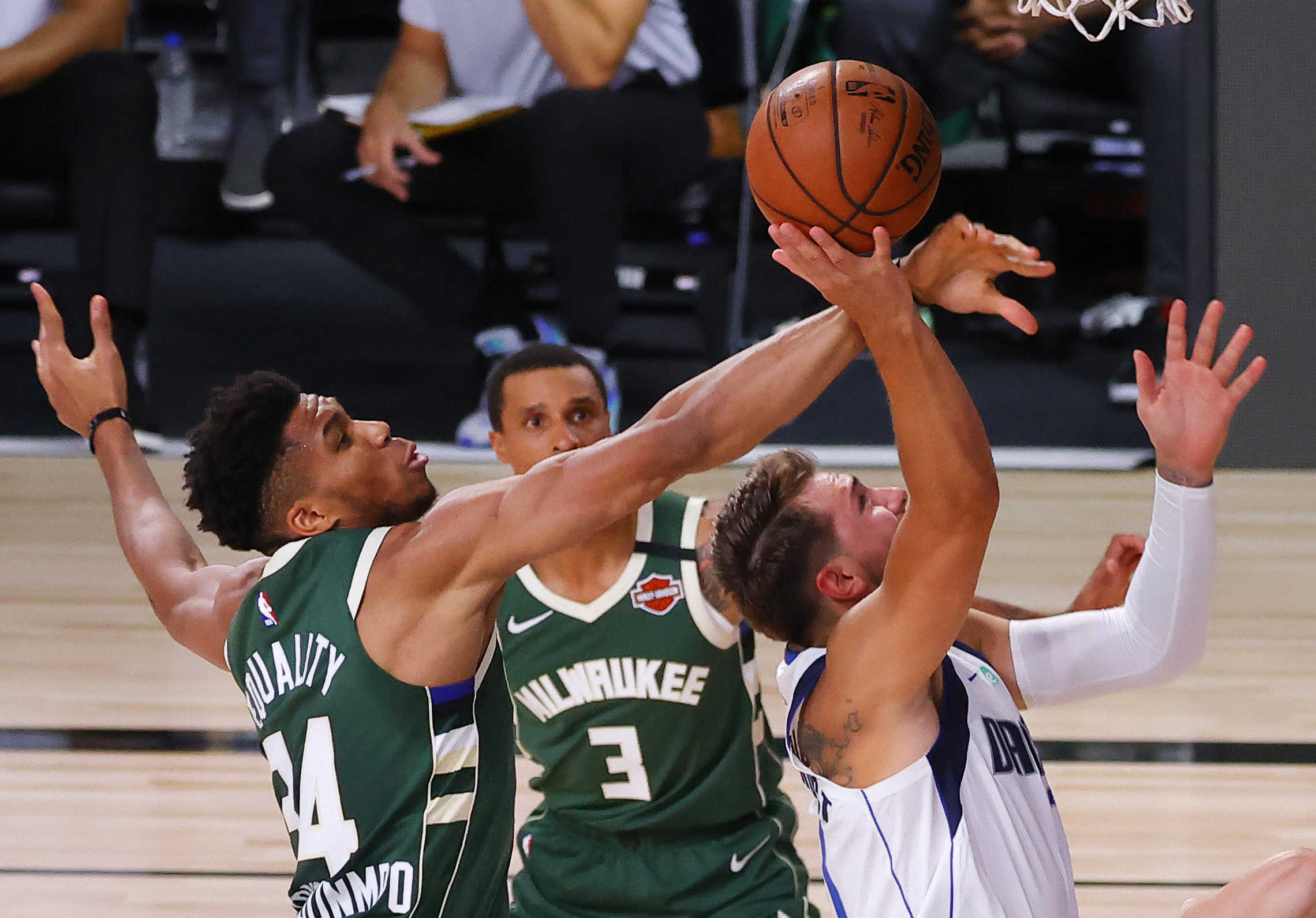 Aug 8, 2020; Lake Buena Vista, Florida, USA; Giannis Antetokounmpo #34 of the Milwaukee Bucks blocks a shot by Luka Doncic #77 of the Dallas Mavericks as George Hill #3 of the Milwaukee Bucks looks on at AdventHealth Arena. Mandatory Credit: Kevin C. Cox
