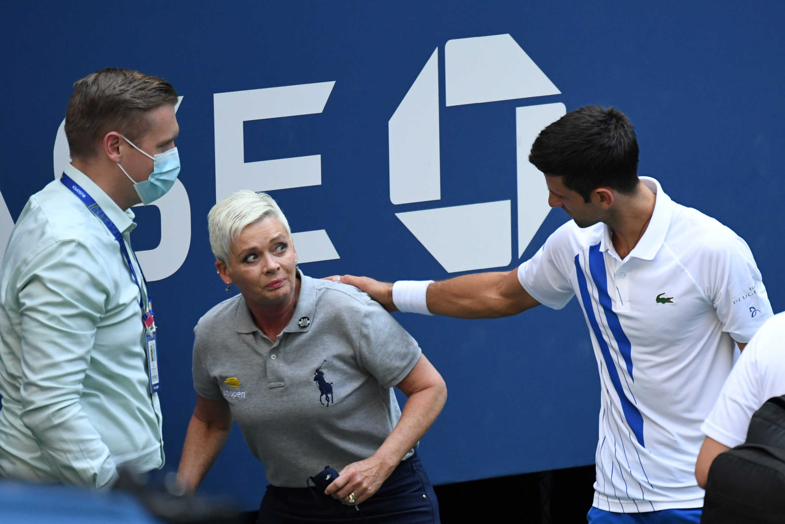 Sep 6, 2020; Flushing Meadows, New York, USA; Novak Djokovic of Serbia and a tournament official tend to a linesperson who was struck with a ball by Djokovic against Pablo Carreno Busta of Spain (not pictured) on day seven of the 2020 U.S. Open tennis tournament at USTA Billie Jean King National Tennis Center. Mandatory Credit: Danielle Parhizkaran-USA TODAY Sports     TPX IMAGES OF THE DAY