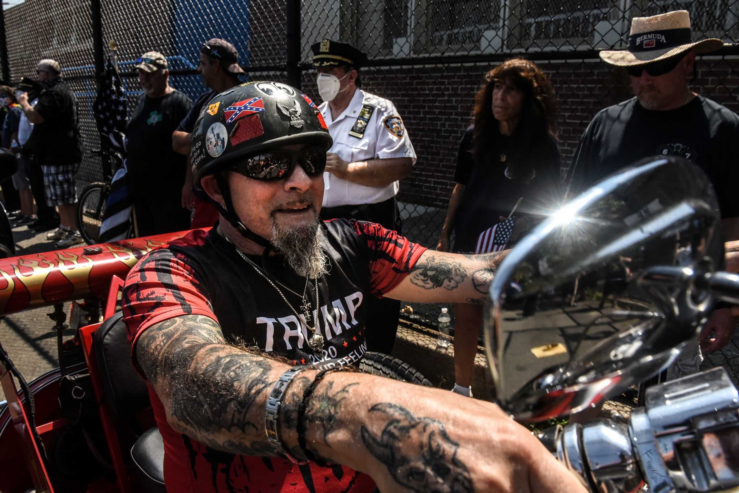 A person wearing a Trump t-shirt rides a motorcycle outside of a "Back the Blue" rally in the Brooklyn borough of New York City, New York, U.S. August 9, 2020. Picture taken August 9, 2020. REUTERS