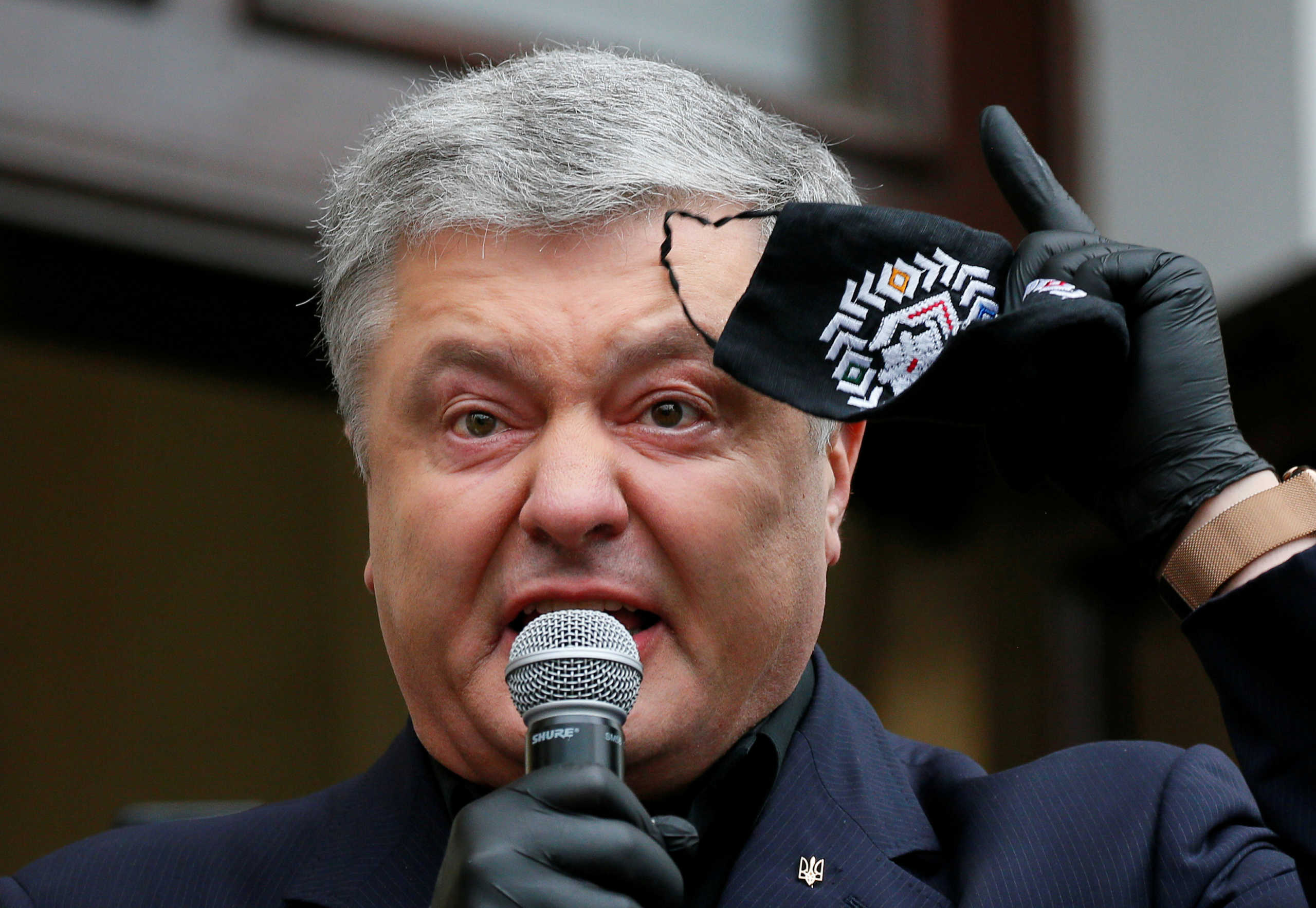 FILE PHOTO: Ukraine's former President Petro Poroshenko, who is suspected of abuse of office, holds a protective face mask while addressing journalists and his supporters before entering a court building in Kyiv, Ukraine June 18, 2020. REUTERS