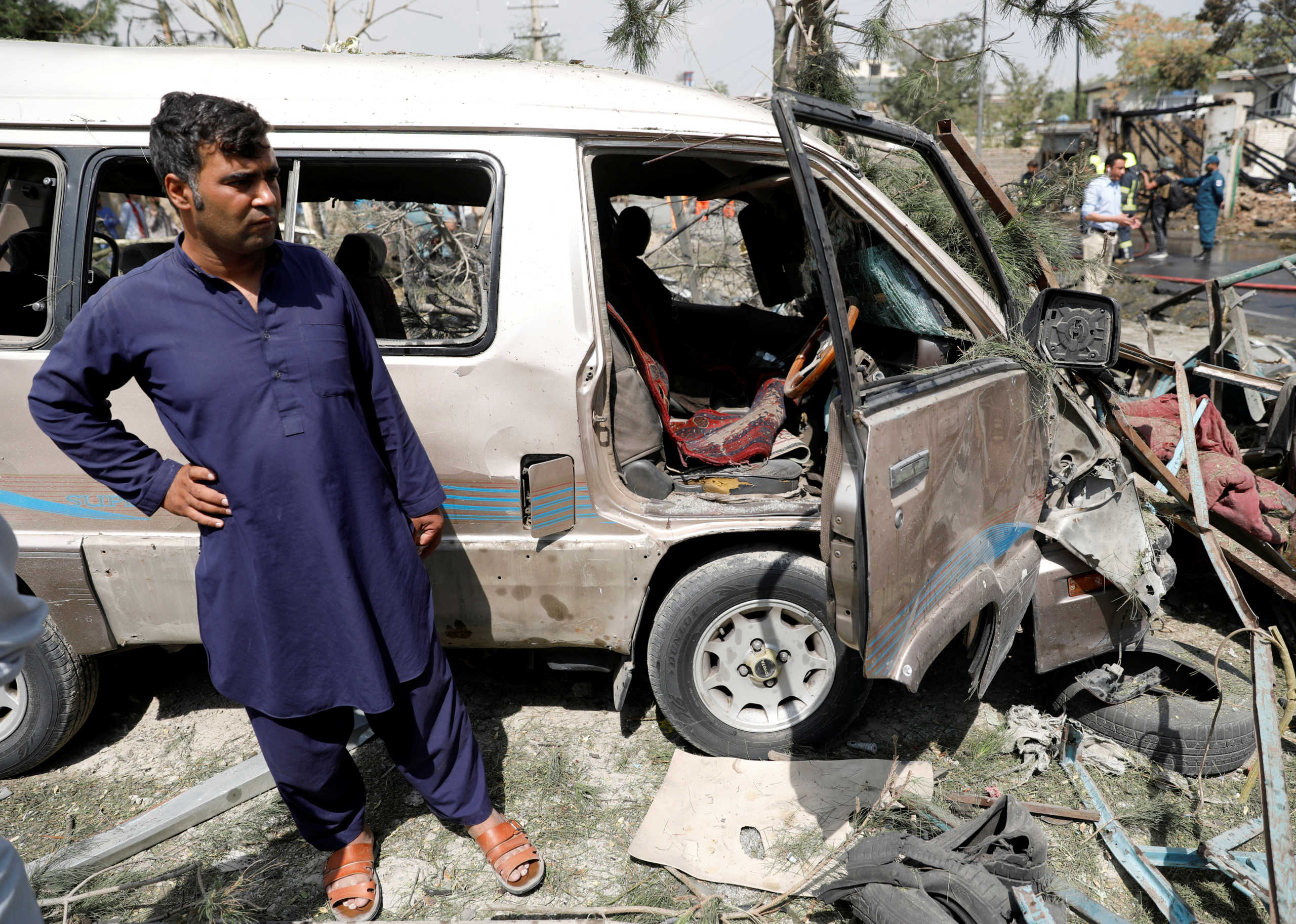 An Afghan man stands next to a damaged vehicle at the site of a blast in Kabul, Afghanistan September 9, 2020. REUTERS