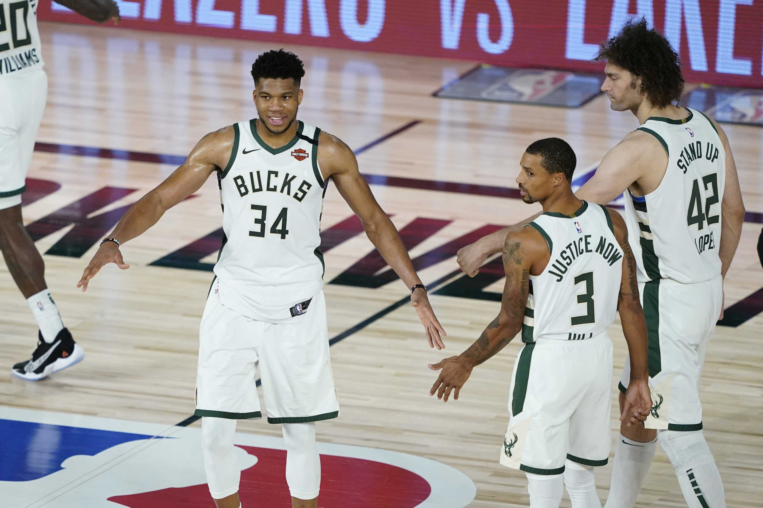 Aug 20, 2020; Lake Buena Vista, Florida, USA; Milwaukee Bucks forward Giannis Antetokounmpo (34) celebrates with guard George Hill (3) and center Robin Lopez (42) after defeating the Orlando Magic in game two of the first round of the 2020 NBA Playoffs at The Field House. Mandatory Credit: Ashley Landis