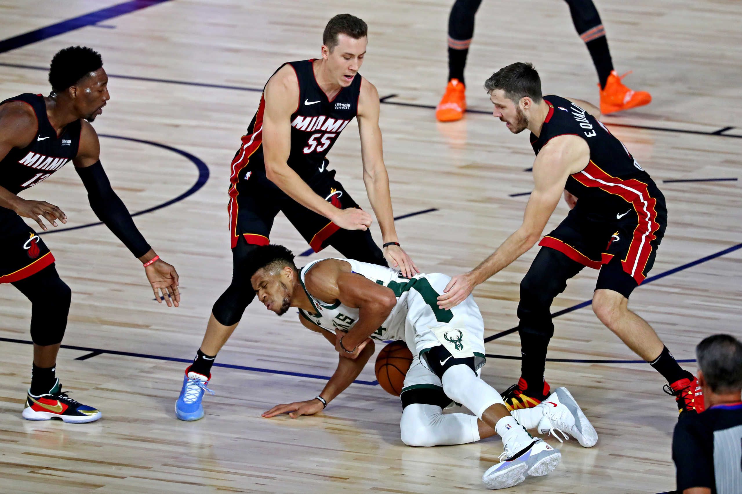Sep 4, 2020; Lake Buena Vista, Florida, USA; Milwaukee Bucks forward Giannis Antetokounmpo (34) goes for the ball against Miami Heat guard Duncan Robinson (55) and guard Goran Dragic (7) during the first quarter in game three of the second round of the 2020 NBA Playoffs at ESPN Wide World of Sports Complex. Mandatory Credit: Kim Klement-USA TODAY Sports