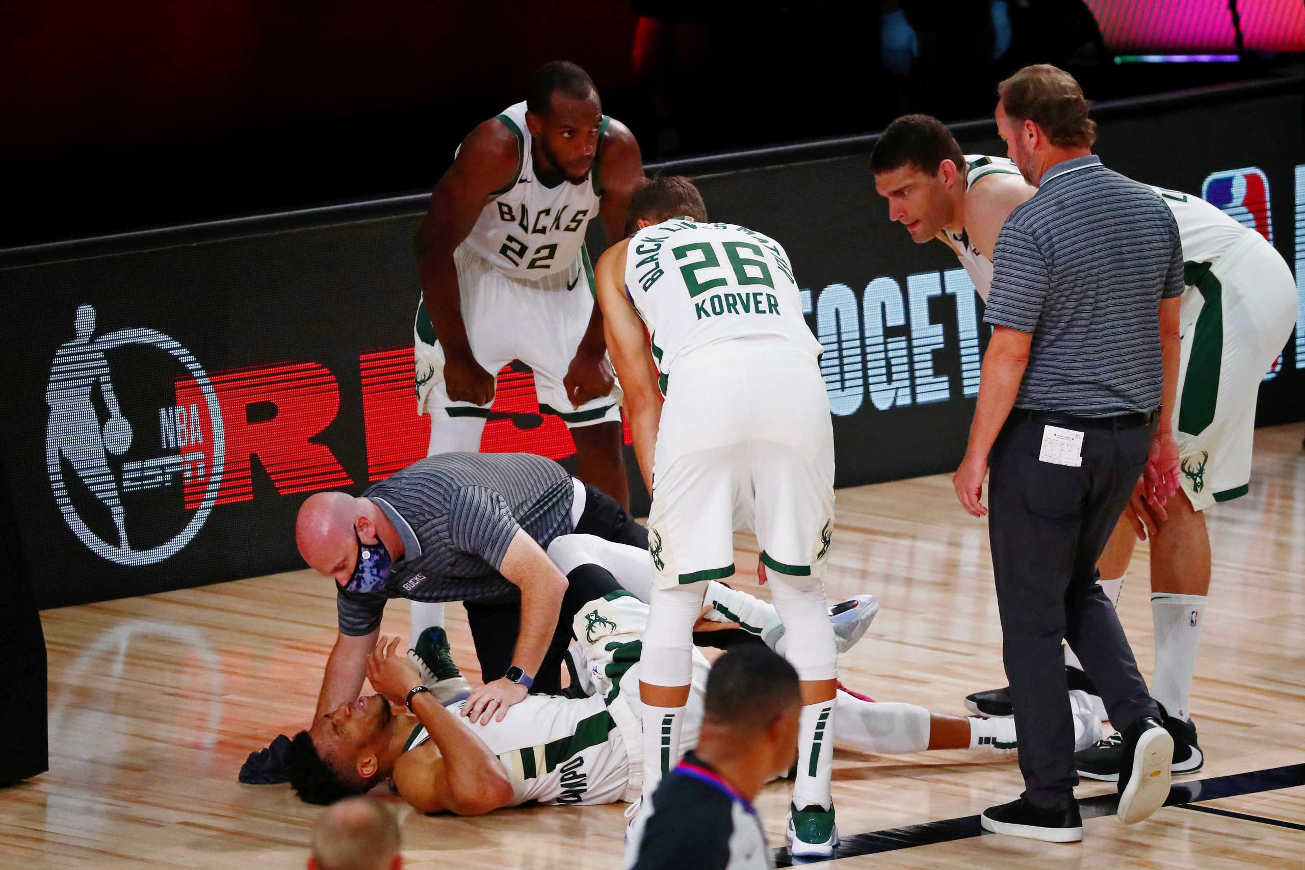 Sep 6, 2020; Lake Buena Vista, Florida, USA; Milwaukee Bucks forward Giannis Antetokounmpo (34) is assessed after an apparent injury during the first half of game four of the second round of the 2020 NBA Playoffs against the Miami Heat at ESPN Wide World of Sports Complex. Mandatory Credit: Kim Klement-USA TODAY Sports