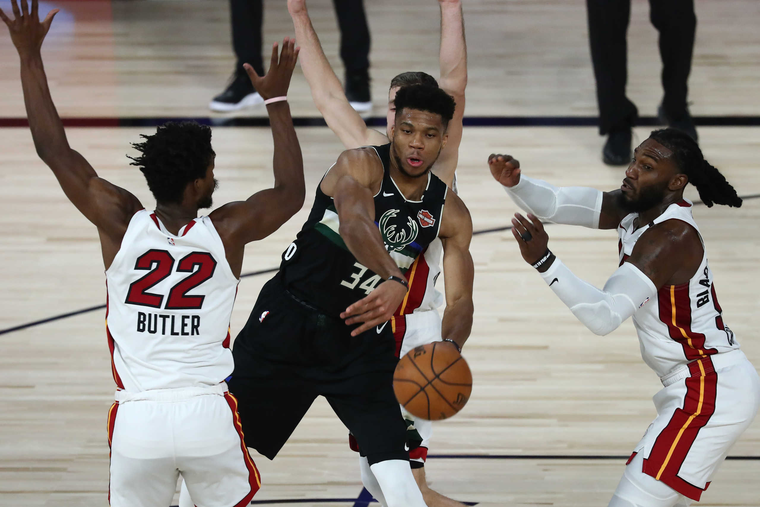 Sep 2, 2020; Lake Buena Vista, Florida, USA; Milwaukee Bucks forward Giannis Antetokounmpo (34) passes the ball agains tMiami Heat forward Jimmy Butler (22) and forward Jae Crowder (right) during the second half of game two of the second round of the 2020 Stanley Cup Playoffs at The Field House. Mandatory Credit: Kim Klement-USA TODAY Sports