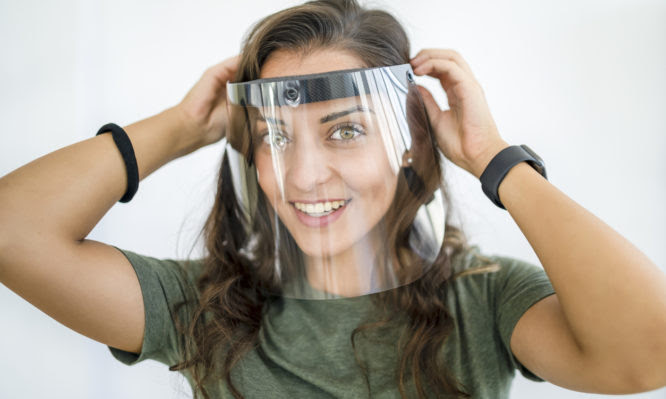 Young woman working with face shield in the office during COVID-19 pandemic