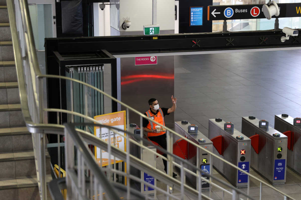 A masked worker gestures to a colleague at the Circular Quay train station as the state of New South Wales continues to report relatively low numbers for new daily cases of the coronavirus disease (COVID-19), in Sydney, Australia, September 7, 2020. REUTERS