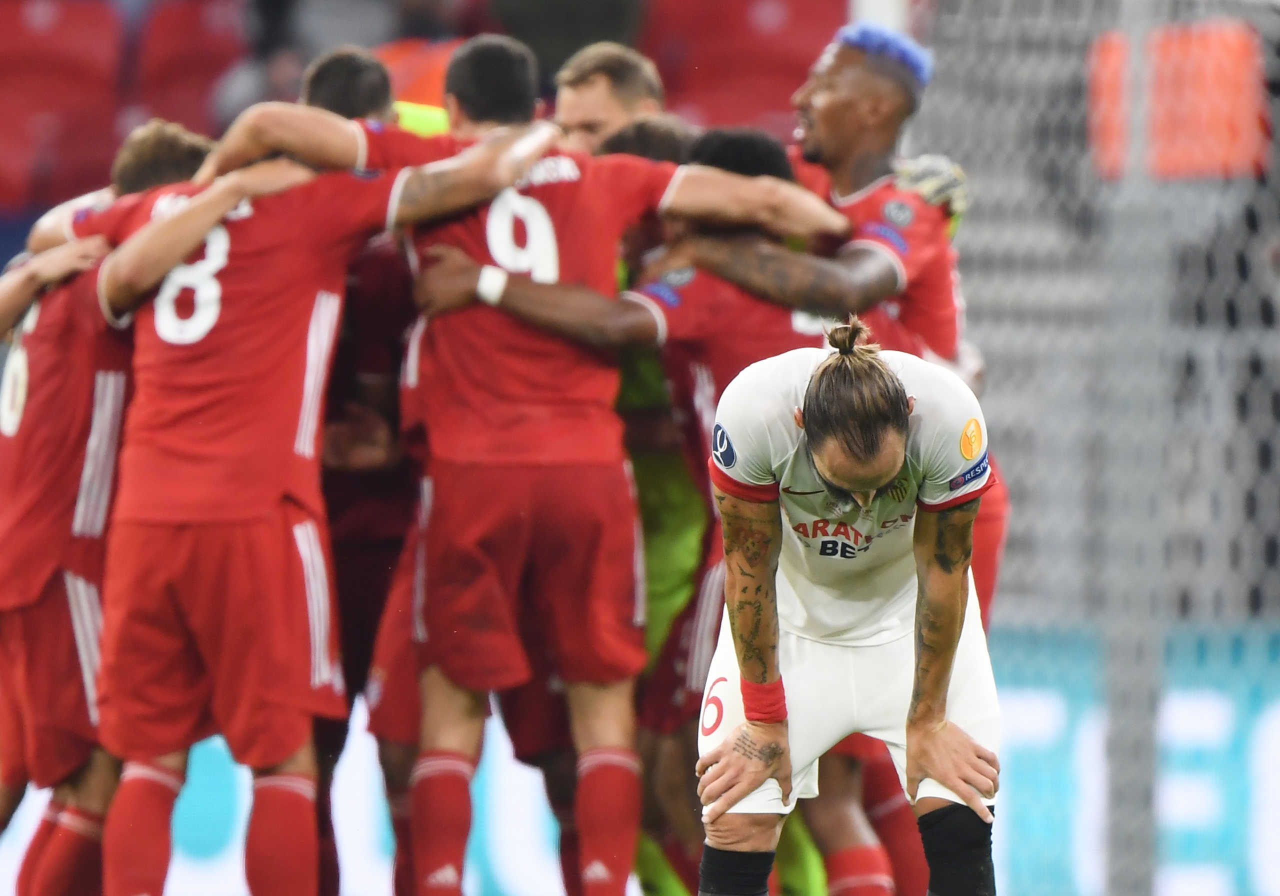 Soccer Football - European Super Cup - Bayern Munich v Sevilla - Puskas Arena, Budapest, Hungary - September 24, 2020. Sevilla's Nemanja Gudelj looks dejected after the match  as Bayern Munich players celebrate Pool via REUTERS
