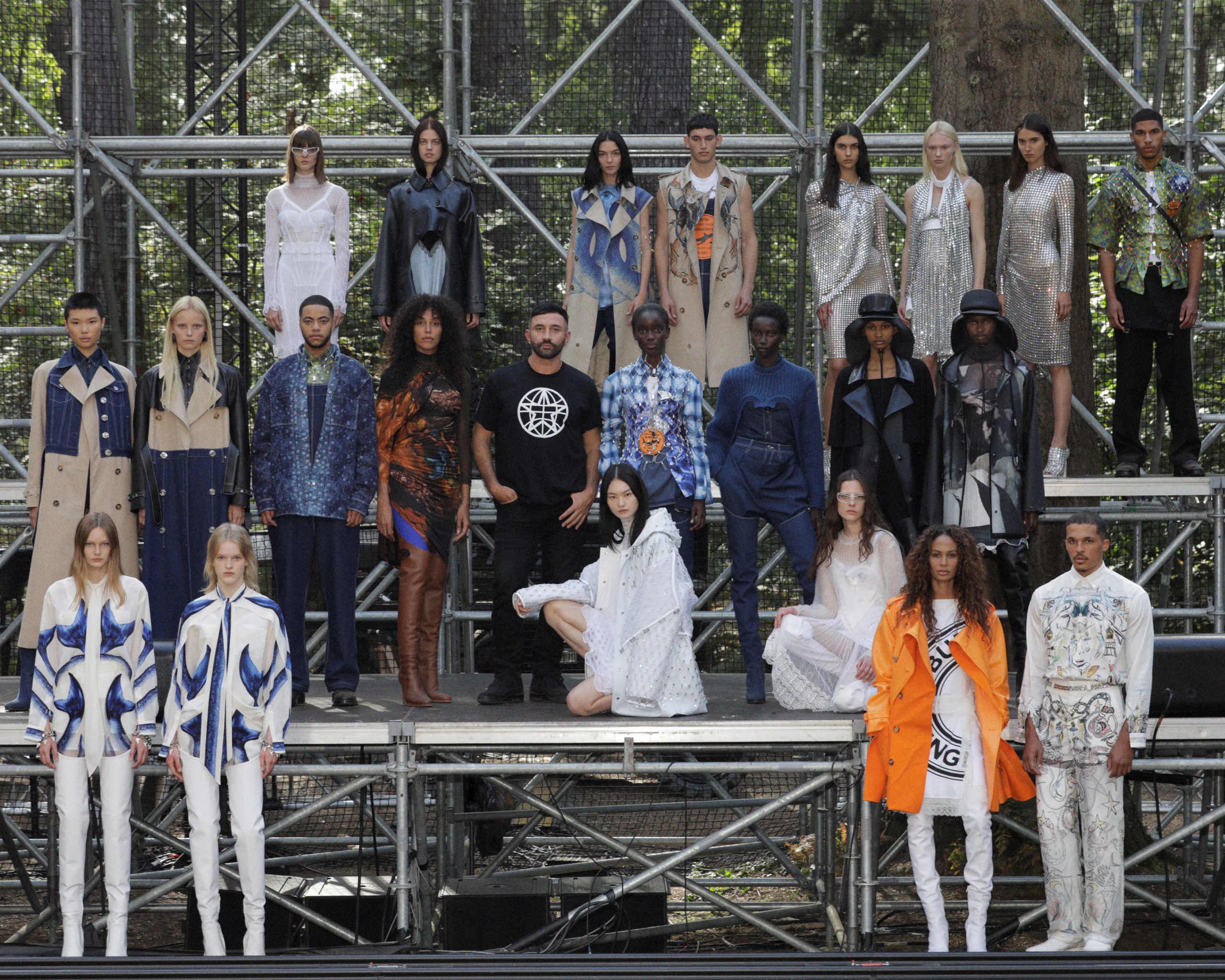 Designer Riccardo Tisci poses backstage with models wearing creations from the Burberry Spring
