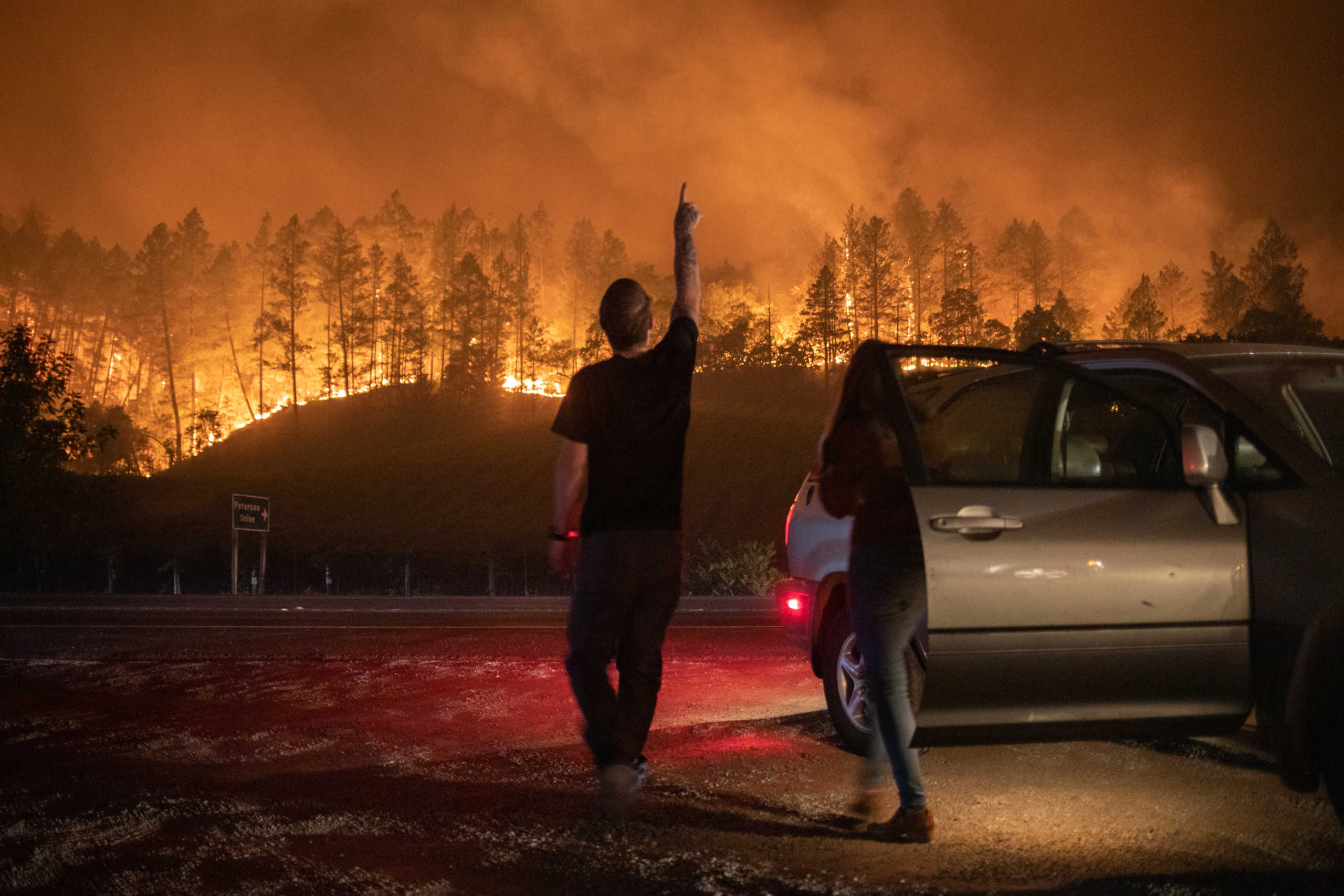 Napa Valley residents Matthew Rivard and Amanda Crean look towards embers from the Glass Fire in Calistoga, California, U.S. September 28, 2020. REUTERS