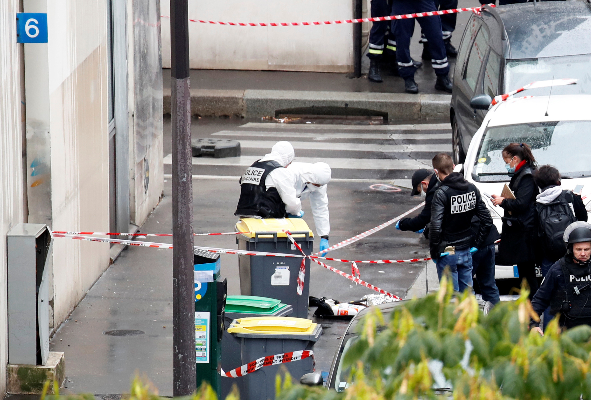Forensic experts investigate the scene of an incident near the former offices of French magazine Charlie Hebdo, in Paris, France September 25, 2020. REUTERS