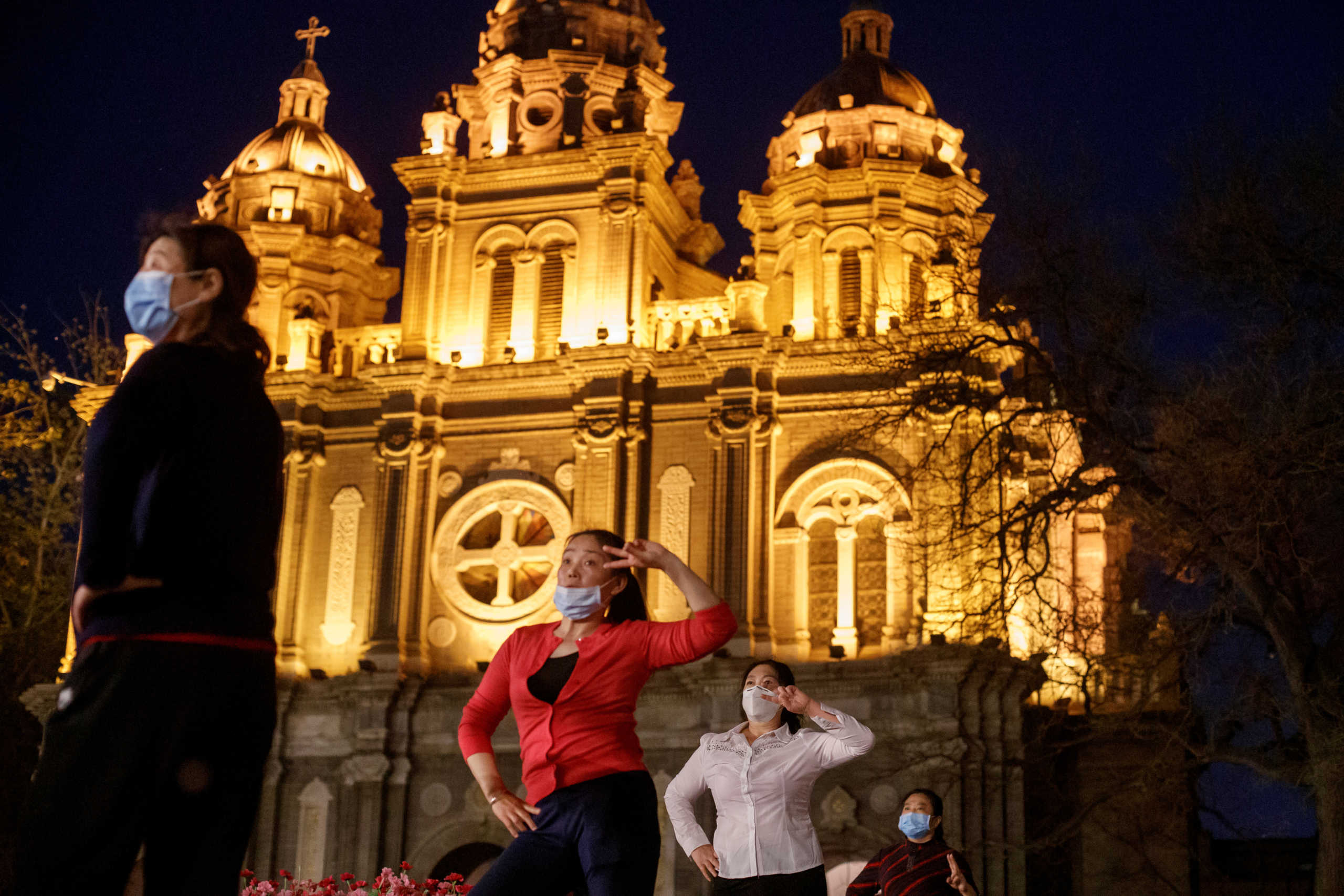 FILE PHOTO: Women take part in a square dance routine in front of St. Joseph's Catholic Church in Beijing, China  April 12, 2020. REUTERS