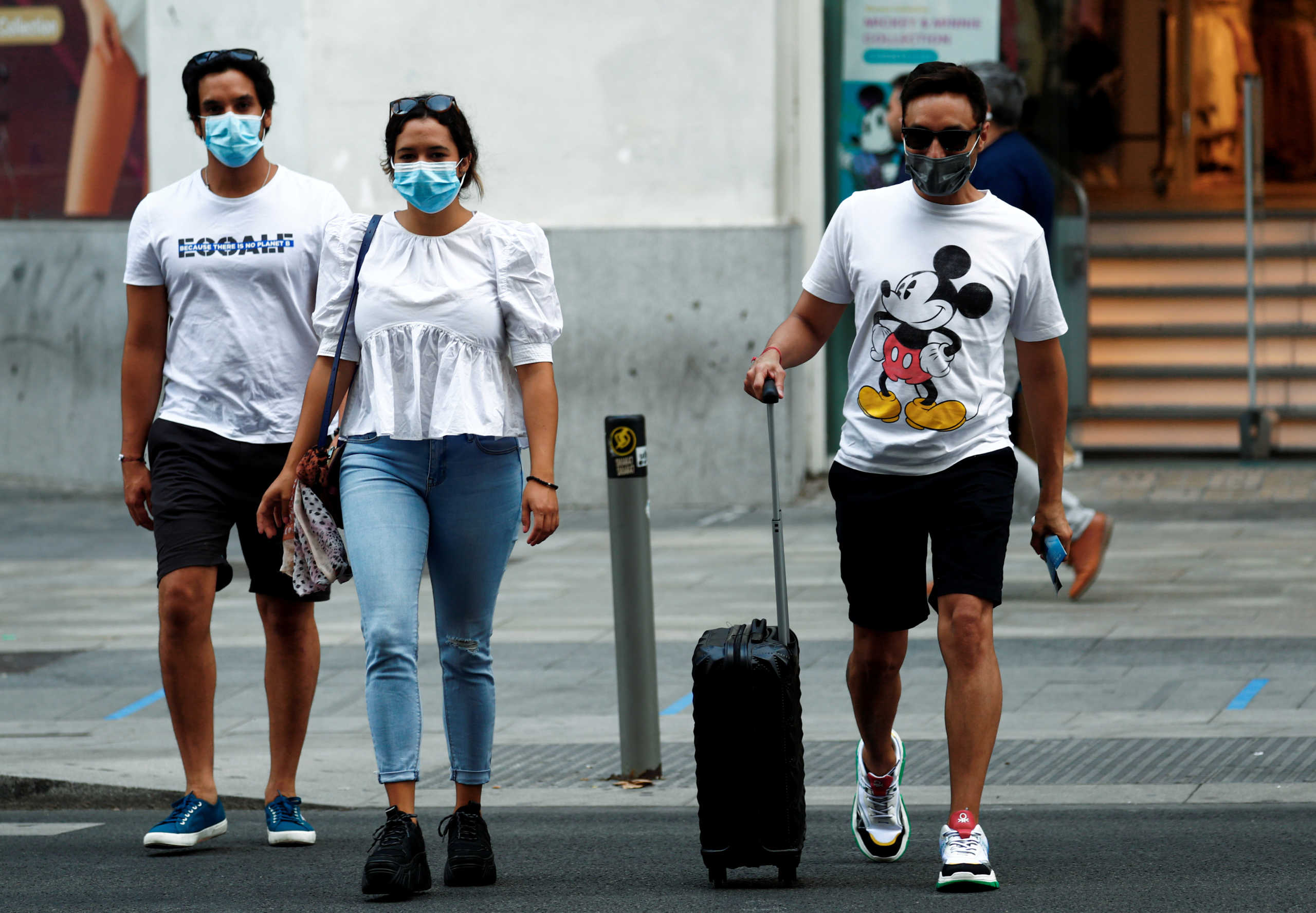 FILE PHOTO: People wearing protective face masks cross the street amid the coronavirus disease (COVID-19) outbreak in Madrid, Spain July 28, 2020. REUTERS