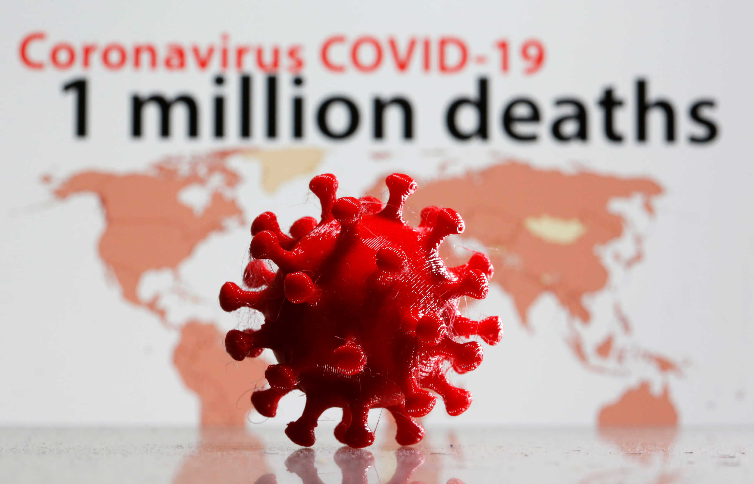 A 3D printed coronavirus model is seen in front of the words "Coronavirus COVID-19, one million deaths" on display in this illustration taken September 28, 2020. REUTERS