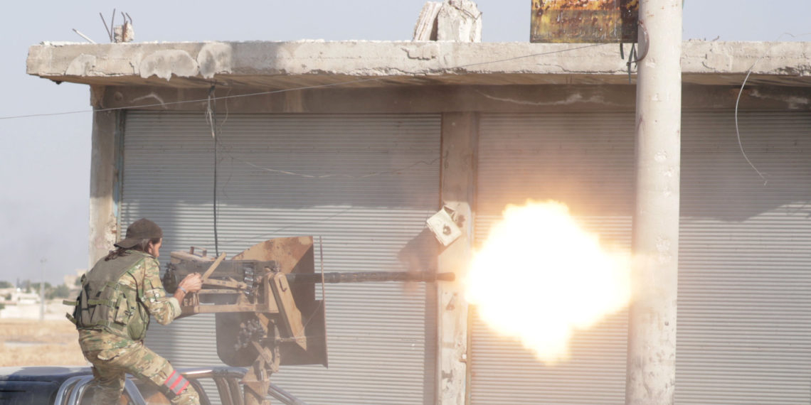 A Turkey-backed Syrian rebel fighter fires a weapon in the town of Tal Abyad, Syria October 13, 2019. REUTERS