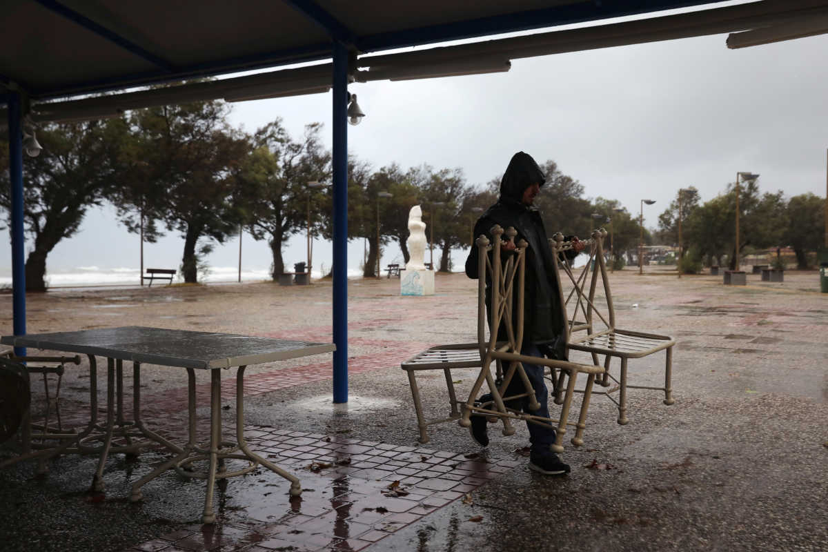 A man carries restaurant chairs in the village of Gastouni, as a rare storm known as a Medicane (Mediterranean hurricane), hit western Greece, September 18, 2020. REUTERS