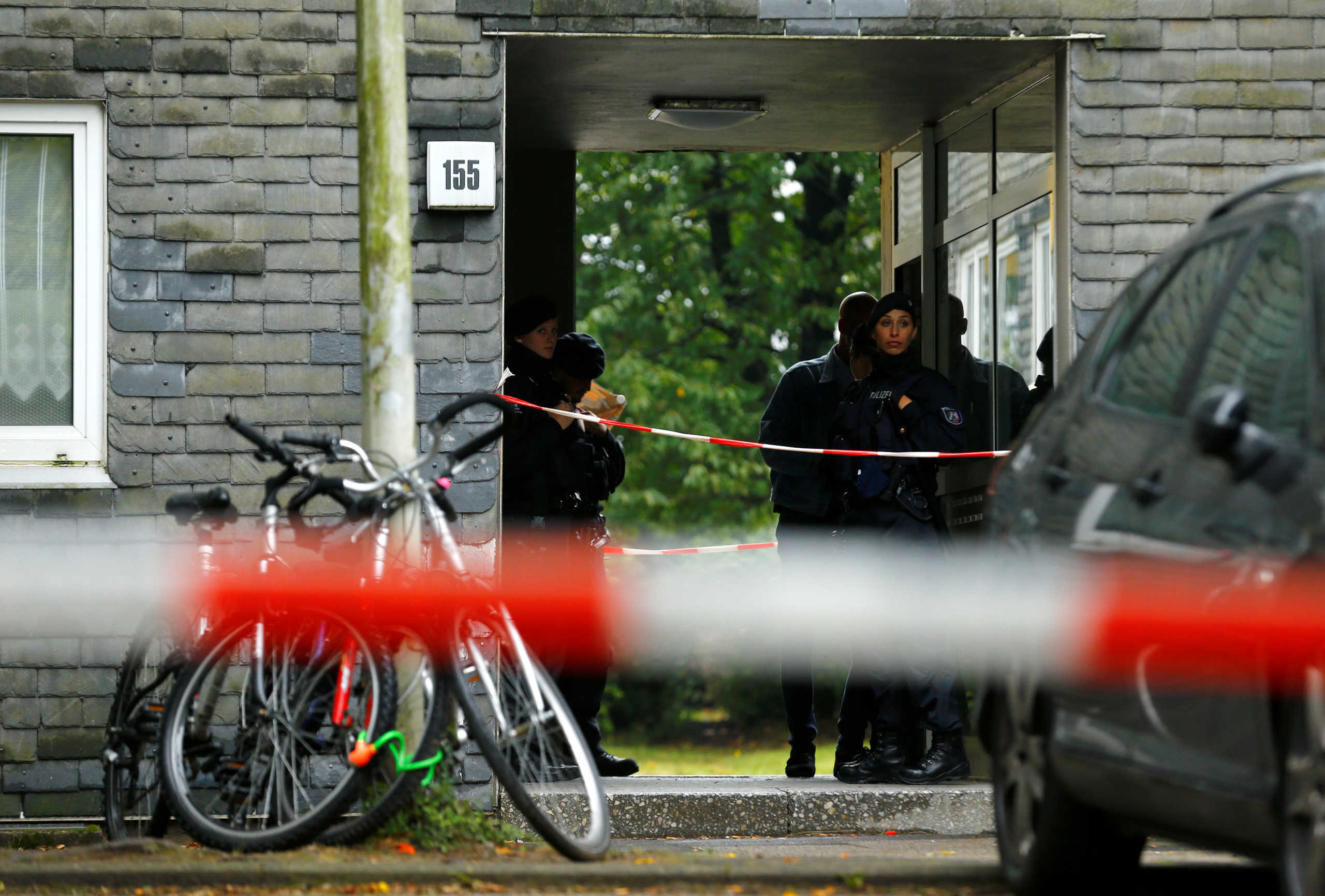 Police officers stand guard at the entrance of a residential building where the bodies of five children were found in the western town of Solingen, Germany, September 3, 2020. REUTERS