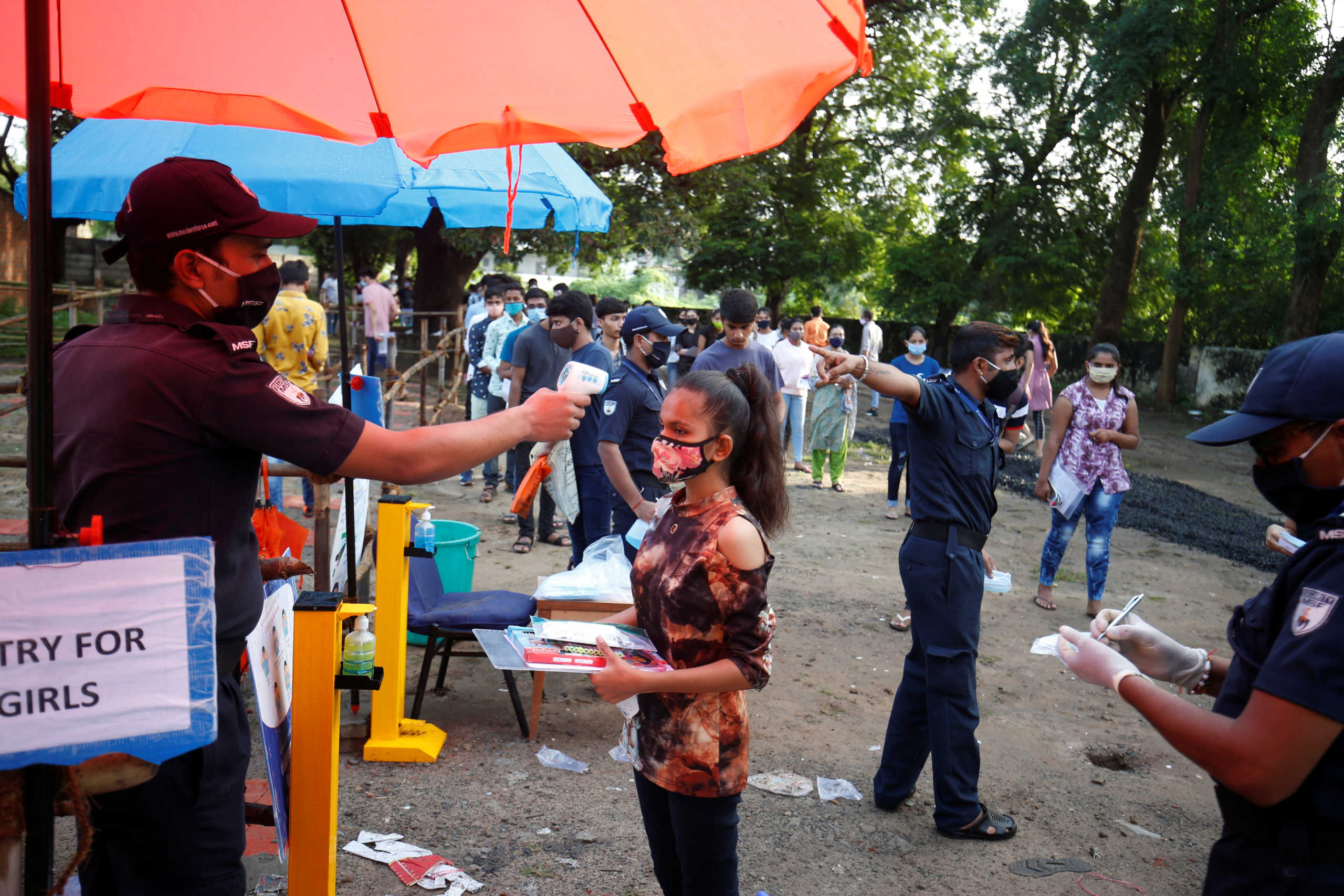 A student wearing a protective face mask gets her temperature measured as she arrives at an examination centre for Joint Entrance Examination (JEE), amidst the spread of the coronavirus disease (COVID-19), in Ahmedabad, India, September 1, 2020. REUTERS