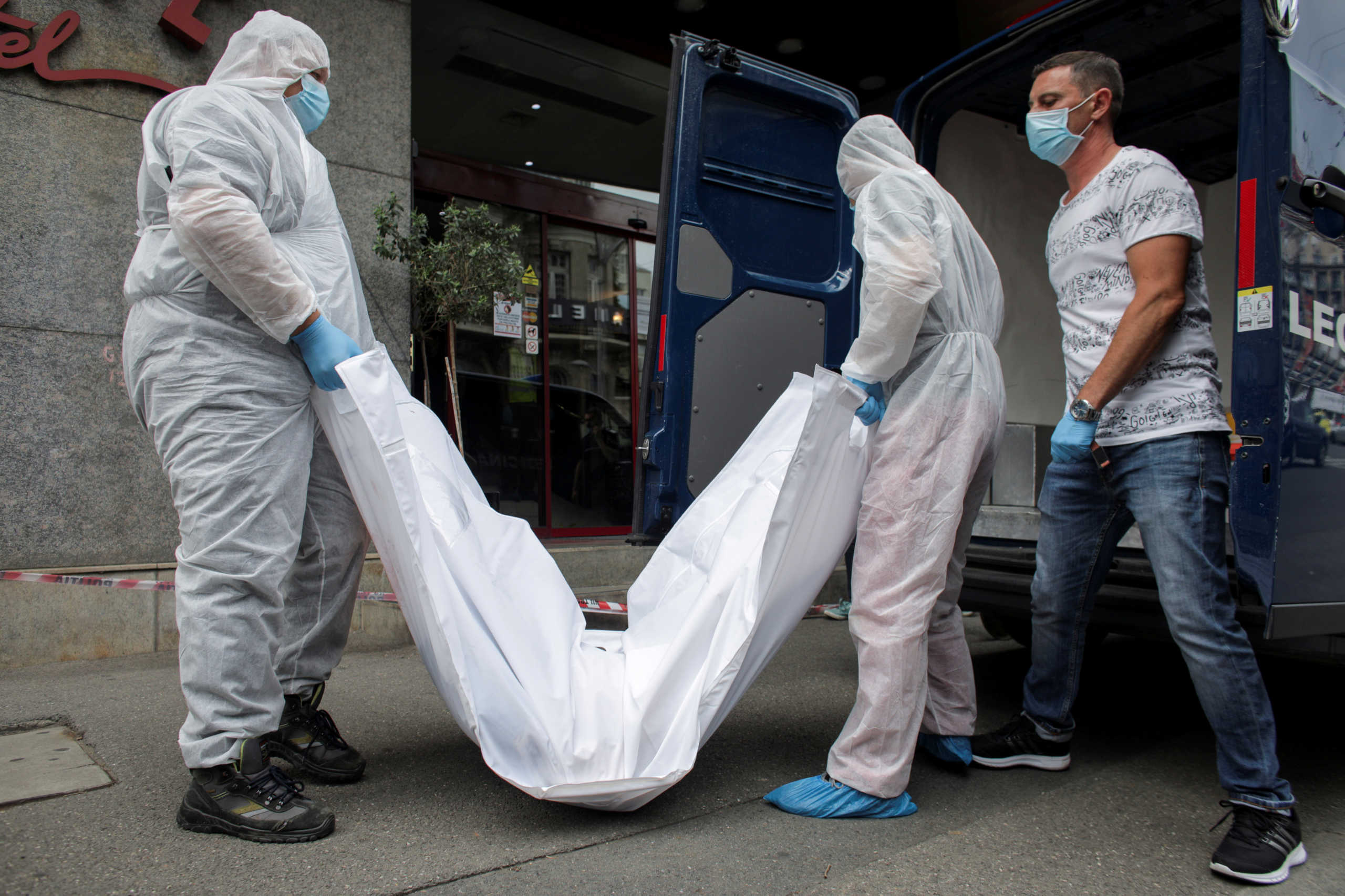 FILE PHOTO: Forensic medicine staff carry a body bag, allegedly containing the remains of Gholamreza Mansouri, outside a hotel in downtown Bucharest, Romania, June 19, 2020. Inquam Photos