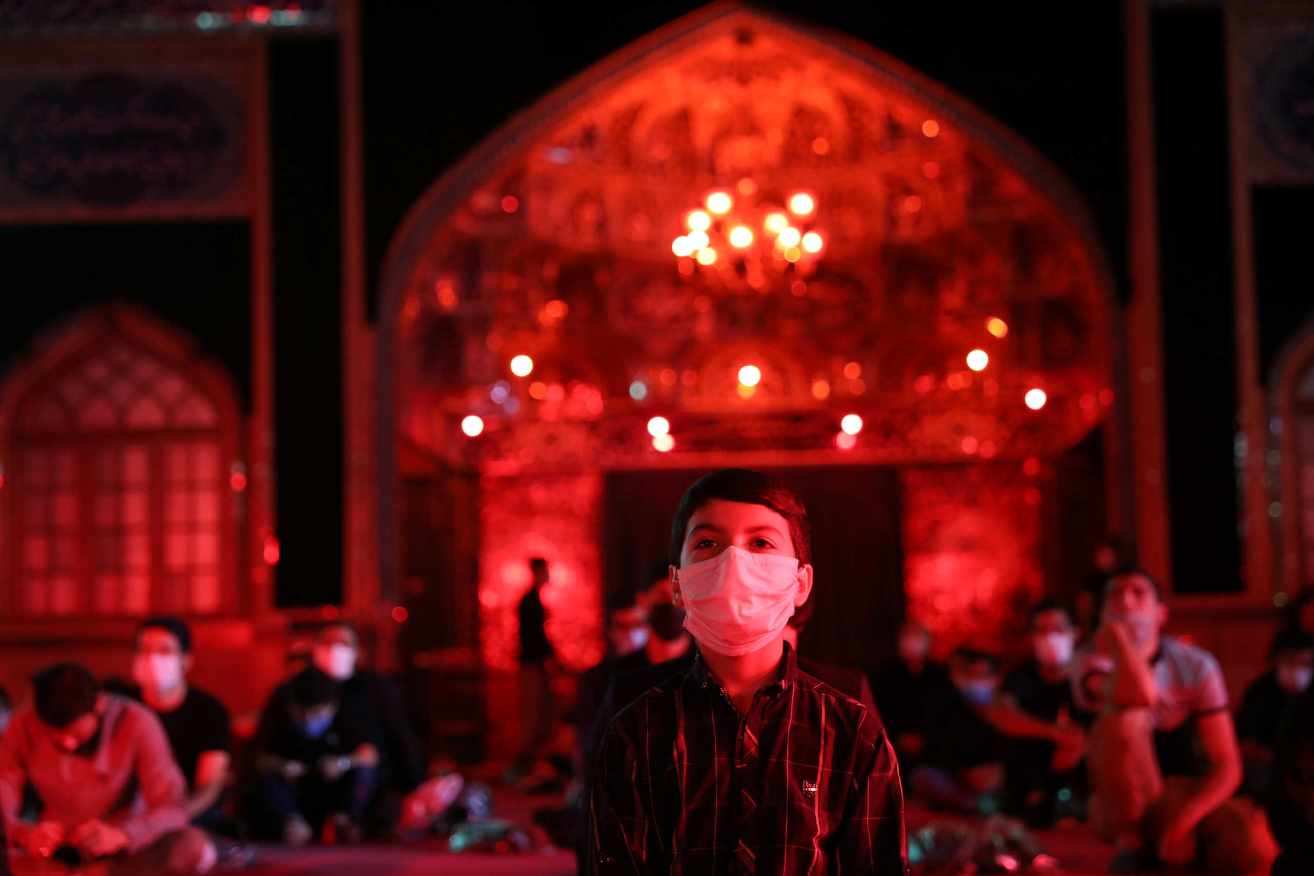 An Iranian Shiite Muslim boy wears a mask as he takes part in a mourning ceremony ahead of Ashura, the holiest day on the Shi'ite Muslim calendar, amid the spread of the coronavirus disease (COVID-19), in northern Tehran, Iran August 23, 2020. Picture taken August 23, 2020. Majid Asgarpour