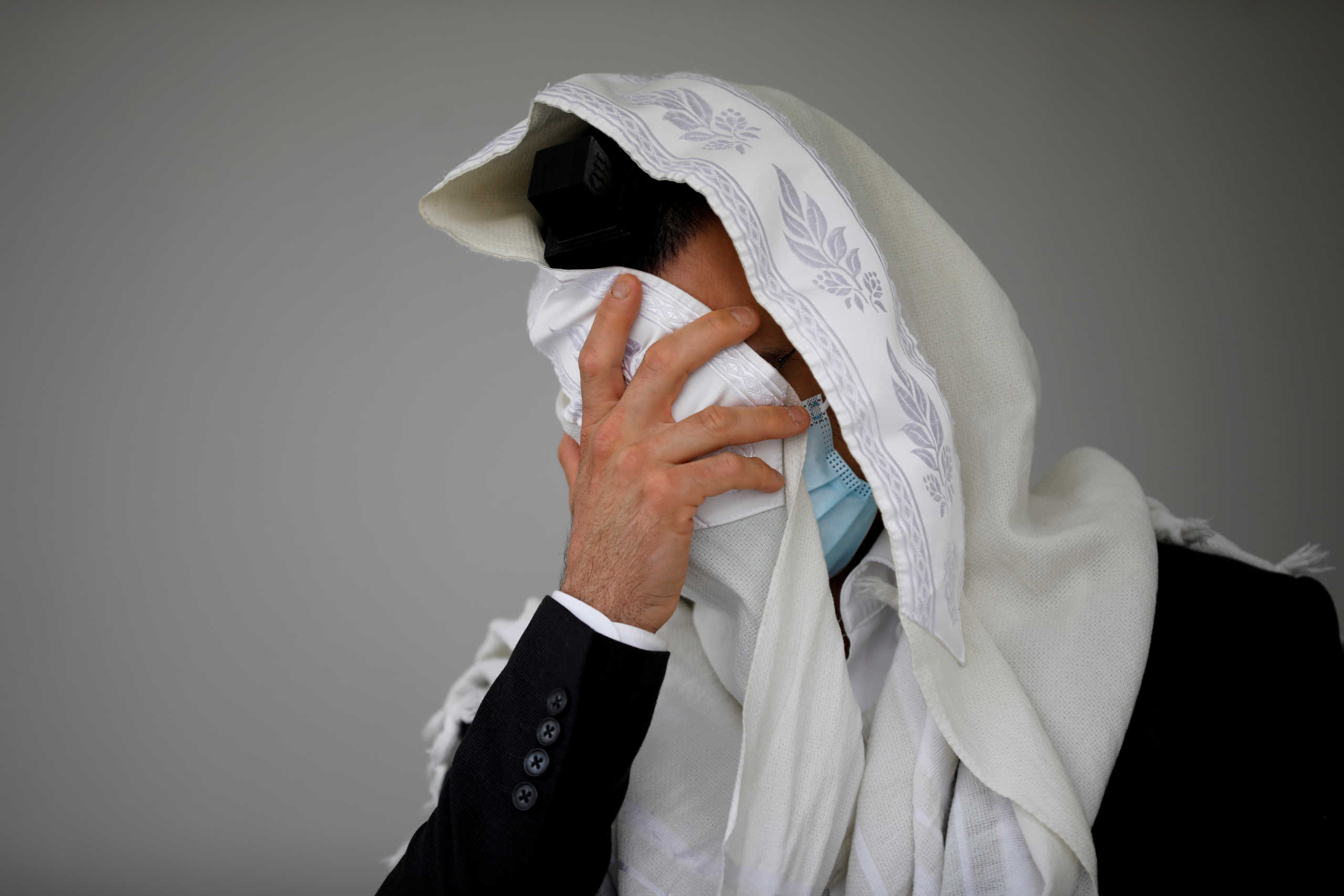 A Jewish worshipper prays the morning prayer outside a residential building before Israel will enter a second nationwide lockdown amid a resurgence in new coronavirus disease (COVID-19) cases, forcing residents to stay mostly at home during the Jewish high-holiday season, in Ashdod, Israel September 18, 2020. REUTERS