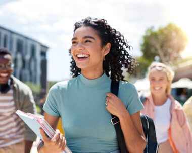 Walking, happy and girl with friends at university for learning, bonding and talking with fun. People, school and group of gen z students commuting outdoor ready for education at college campus.