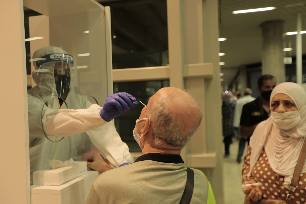 A health worker checks a passenger arriving at Queen Alia International Airport after a regular international flights resume after a closure due to the coronavirus disease (COVID-19) outbreak, in Amman, Jordan, September 8, 2020.  The Prime Ministry Office