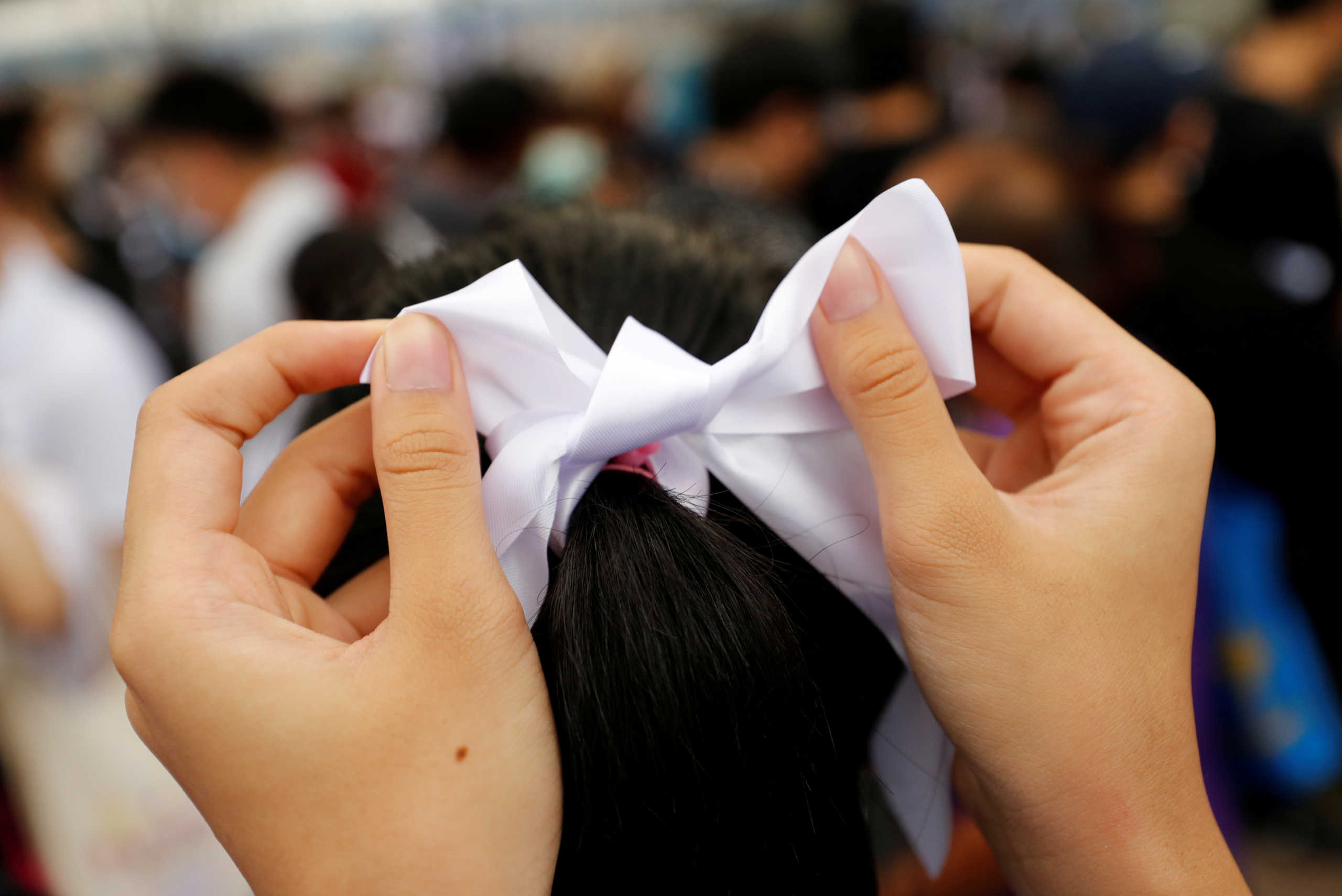 FILE PHOTO: A person wears a white ribbon as anti-government protesters and students attend a demonstration demanding the government to resign, in front of the Ministry of Education in Bangkok, Thailand September 5, 2020. REUTERS