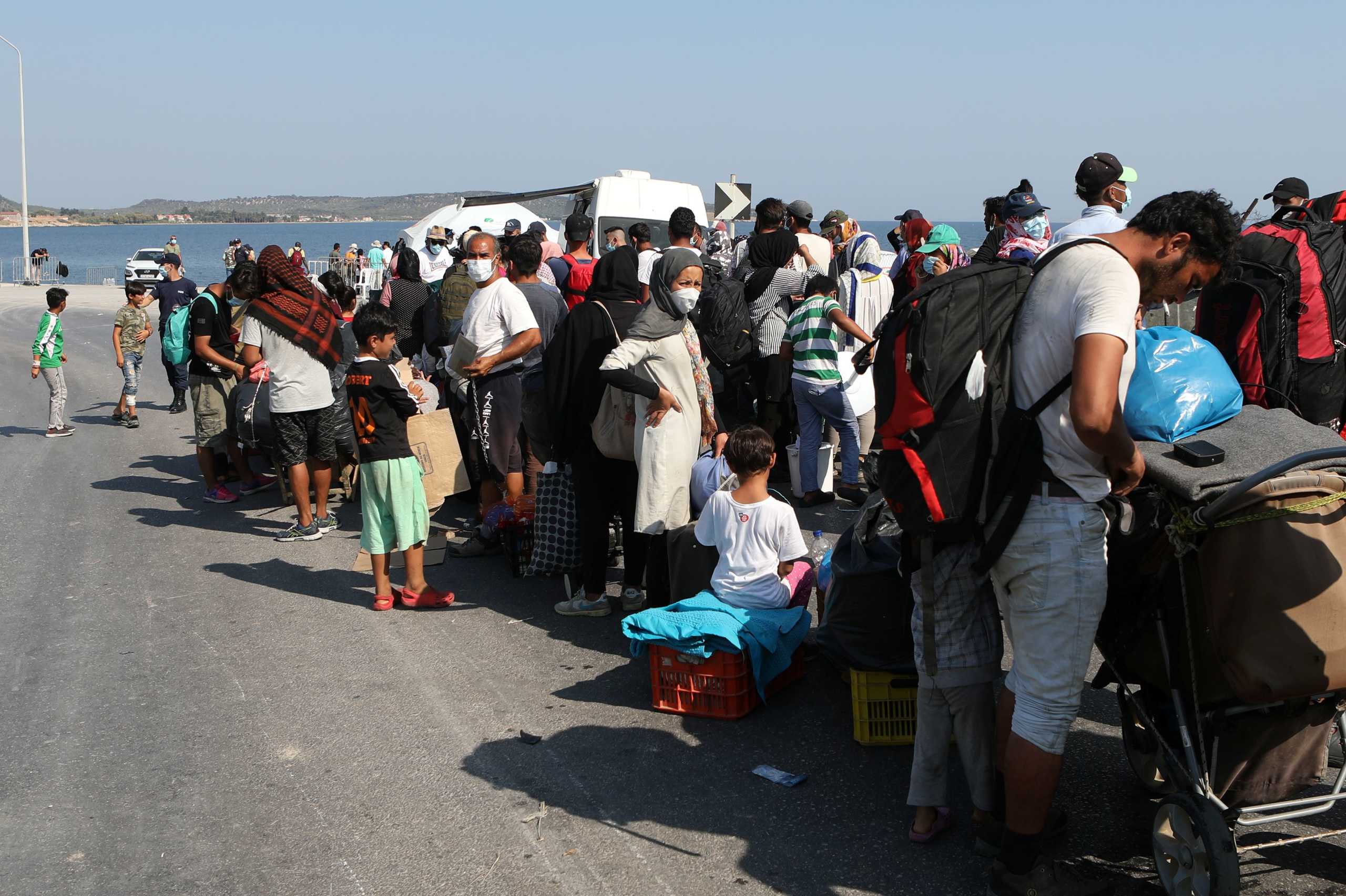 Refugees and migrants from the destroyed Moria line up to enter a new temporary camp during a police operation, on the island of Lesbos, Greece, September 17, 2020. REUTERS